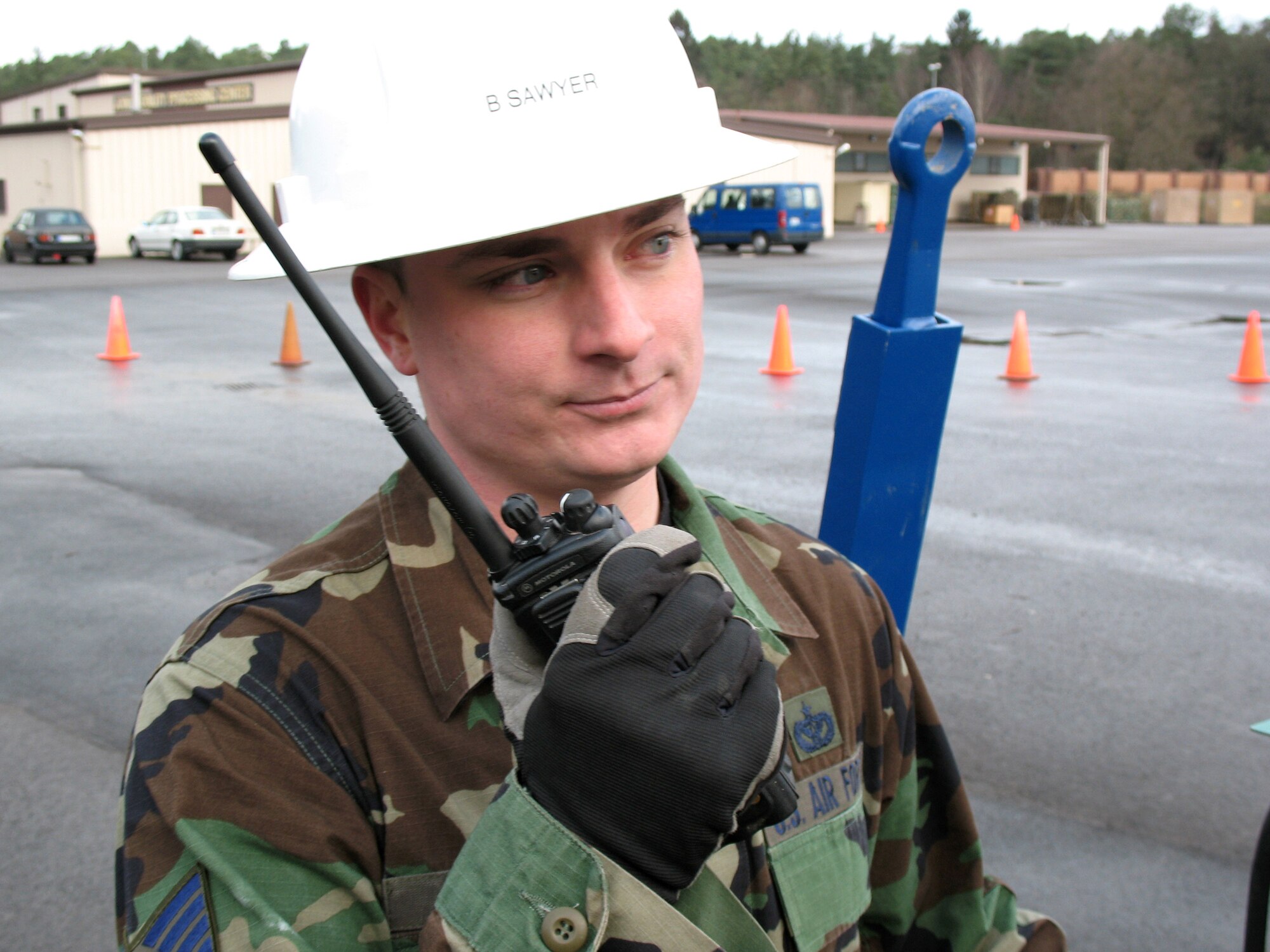 Staff Sgt. Brian Sawyer, an electrical systems craftsman at Ramstein Air Base, Germany, communicates with his civil engineer team while lowering a light pole on the flightline Feb. 13 to repair non-working lights. (U.S. Air Force photo/Airman 1st Class Mara Title) 