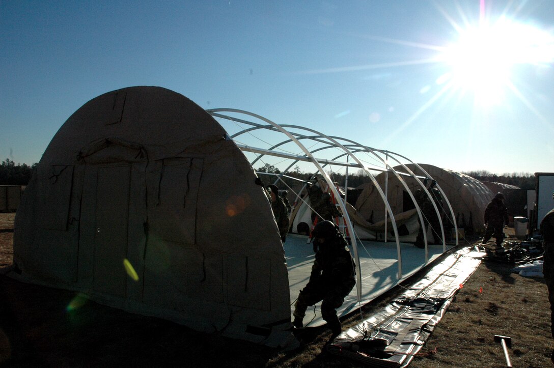 U.S. Air Force Airmen deployed with the "421st Air Expeditionary Group" build an Alaskan tent during operations for Air Force Exercise Eagle Flag 07-3 Feb. 11, 2007, at Naval Air Engineering Station Lakehurst, N.J.  The exercise, operated by the Air Mobility Warfare Center's 421st Combat Training Squadron, Fort Dix, N.J., tests and trains Airmen on their expeditionary combat support skills.  (U.S. Air Force Photo/Tech. Sgt. Scott T. Sturkol)