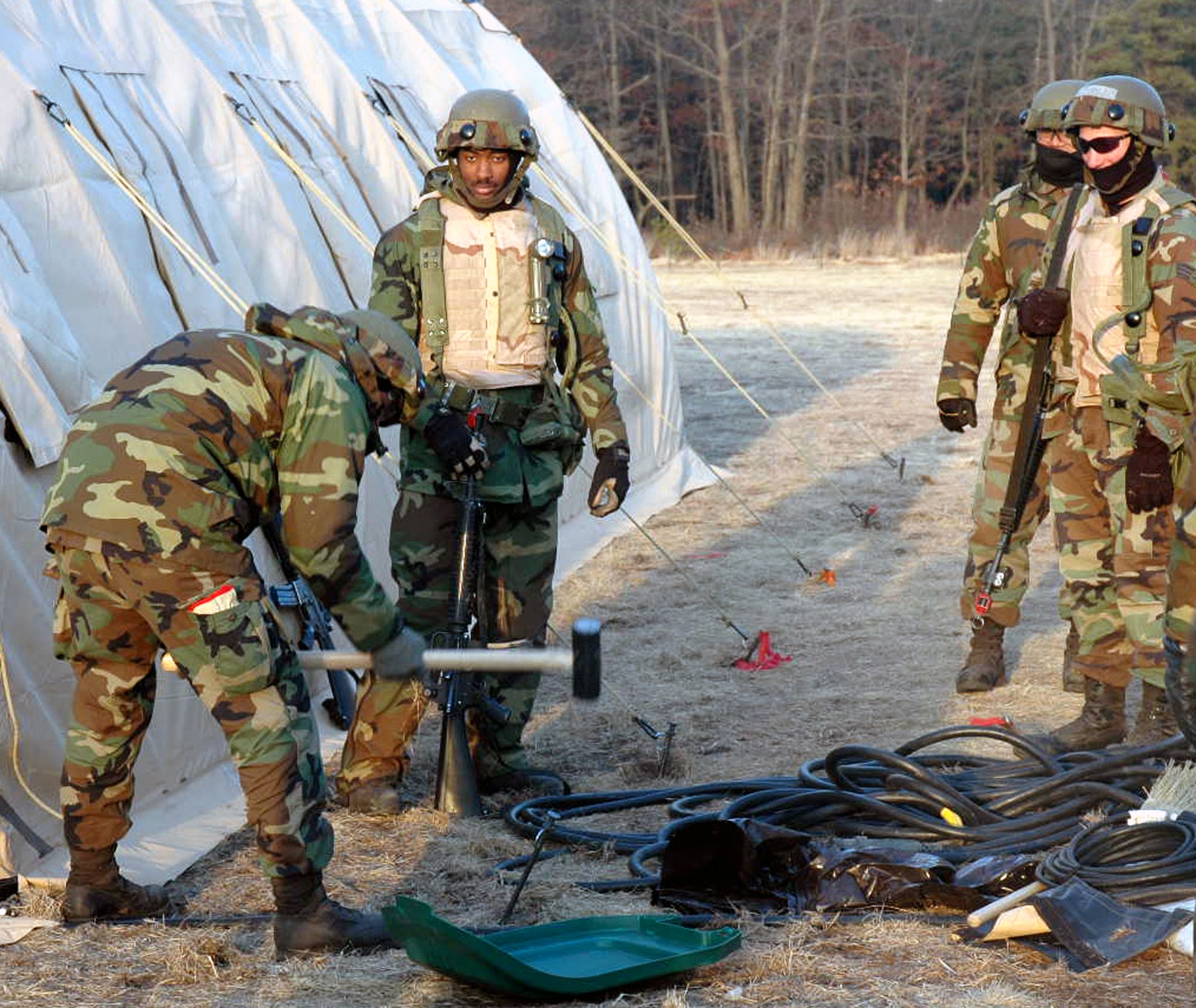 U.S. Air Force Airmen deployed as part of "421st Air Expeditionary Group" pound stakes for a tent during operations for Air Force exercise Eagle Flag 07-3 Feb. 11, 2007, at Naval Air Engineering Station Lakehurst, N.J. The exercise is operated by the Air Mobility Warfare Center, Ft. Dix, N.J.  (U.S. Air Force photo/Tech. Sgt. Ron Rogers) 