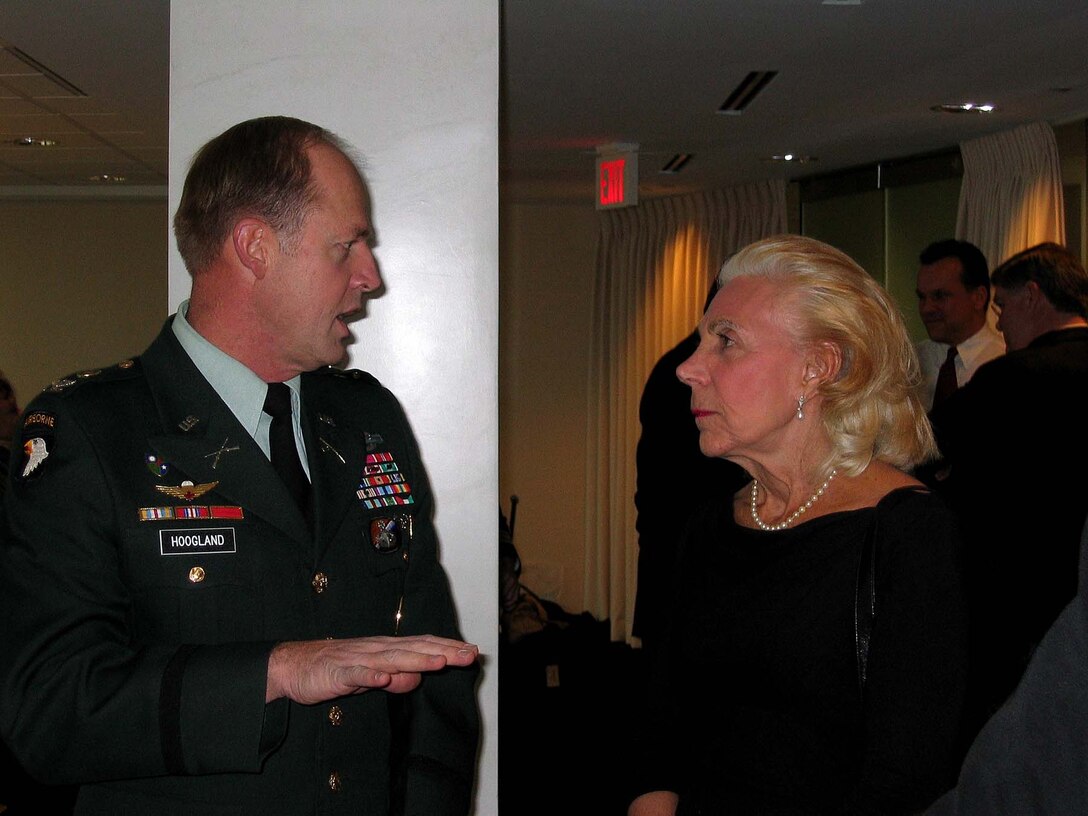 Army Ranger Col. Steve Hoogland chats with  cartoonist Bunny Hoest before the send-off ceremony.  Hoest's creation, Howard Huge, featured weekly in Parade  magazine, is part of the 2004 calendar. The calendars will  be sent to more than 600,000 troops serving overseas. Task  Force Calendar 04 is sponsored by the White House  Commission on the National Moment of Remembrance. Photo by  K.L. Vantran.