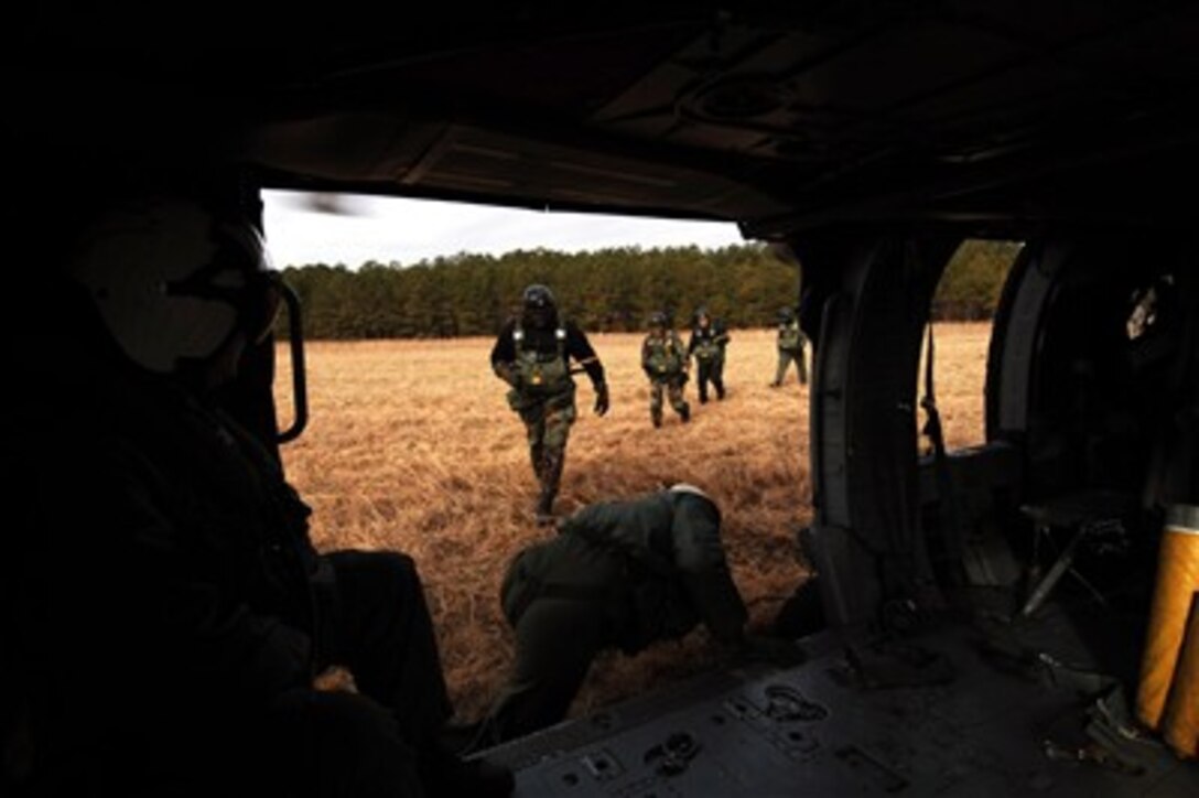 Sailors assigned to Explosive Ordnance Disposal Unit 2 board an MH-60S Seahawk assigned to the "Chargers" of Helicopter Combat Support Squadron 26 to conduct static-line jump operations at Fort Pickett,Va., Feb. 8, 2007. 