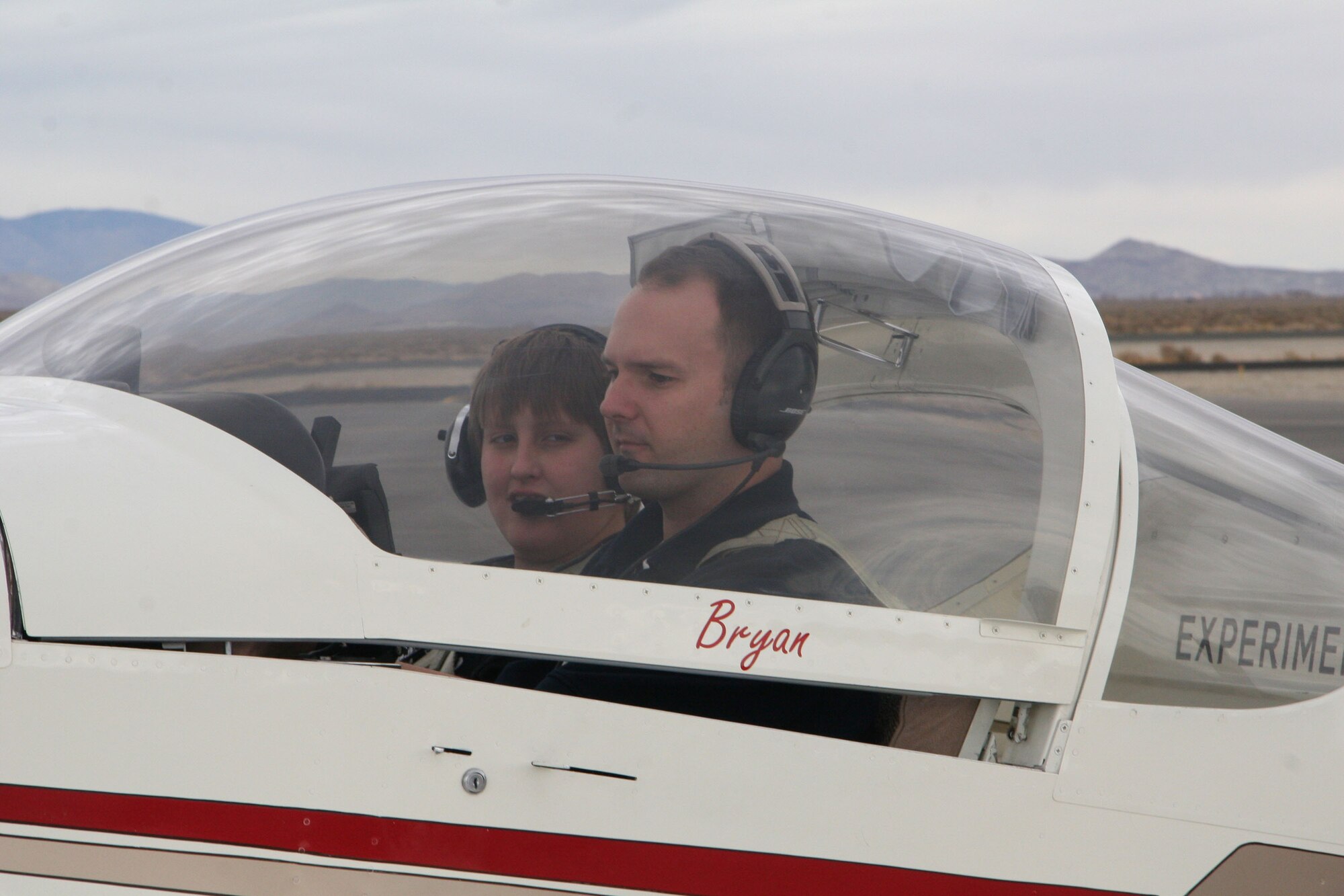 Capt. Bryan Duke, 416th Flight Test Squadron F-16 Falcon pilot and Experimental Aircraft Association member, prepares a Young Eagle participant for a flight during the EAA's Lancaster Chapter 49 and Edwards Chapter 1000 Young Eagles Rally at Fox Field in Lancaster, Calif., on Feb. 10, 2007. (Photo by Marti Zamorano)