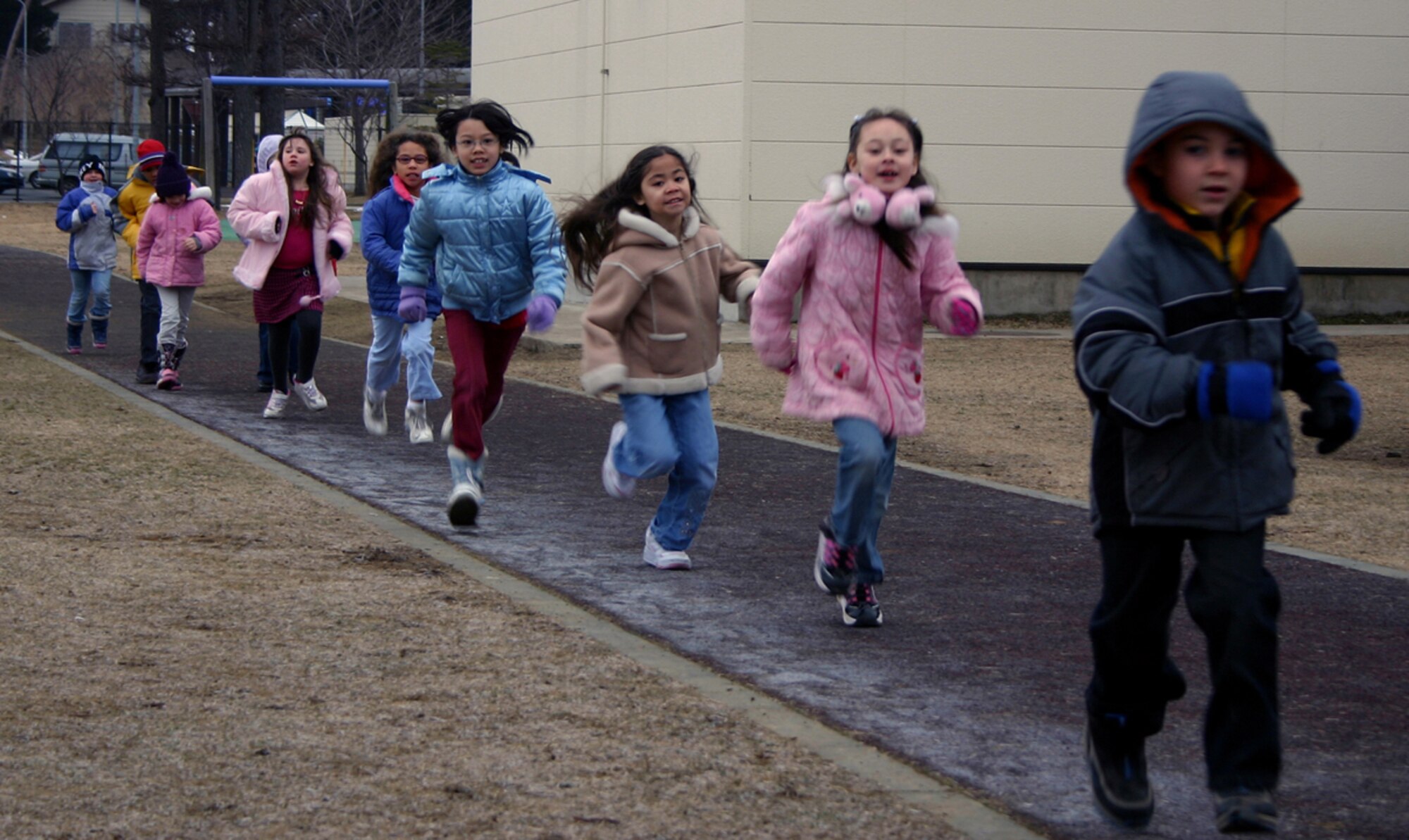02/09/2007 -- MISAWA AIR BASE, Japan -- Sollars Elementary School children run along the sidewalk in an effort to meet the school's challenge of jogging the length of around the world. In the spring of 2006,  several classes took up the challenge and began to record miles toward the goal of 7,890 miles. Progress was tracked on a huge chart in the multi-purpose room. The students tallied the last set of miles and met their goal before semester break. (Courtesy photo)