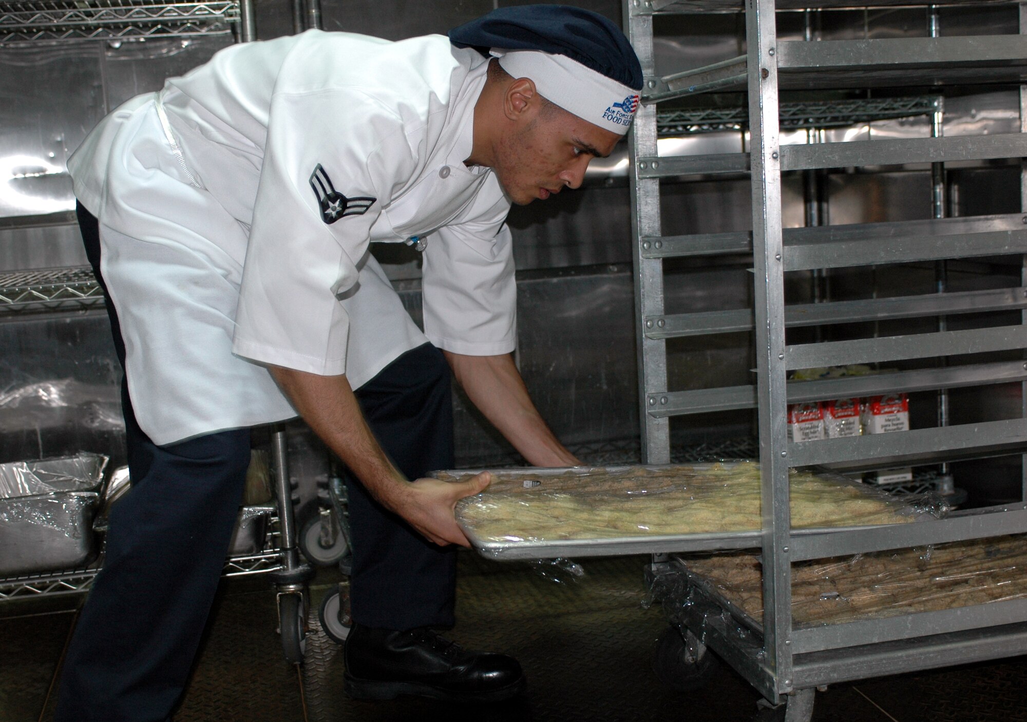 Airman 1st Class Daniel Johnson properly stores food in the food locker. The 60th Services Squadron’s Food Service Flight is preparing for the 2007 Air Force Hennessy Award competition. The award is presented to the Air Force base with the best food service program, evaluates all aspects of a facility’s program including kitchen operations, serving and dining operations, training and readiness, sanitation and repair, and management. (U.S. Air Force photo by Staff Sgt. Candy Knight)