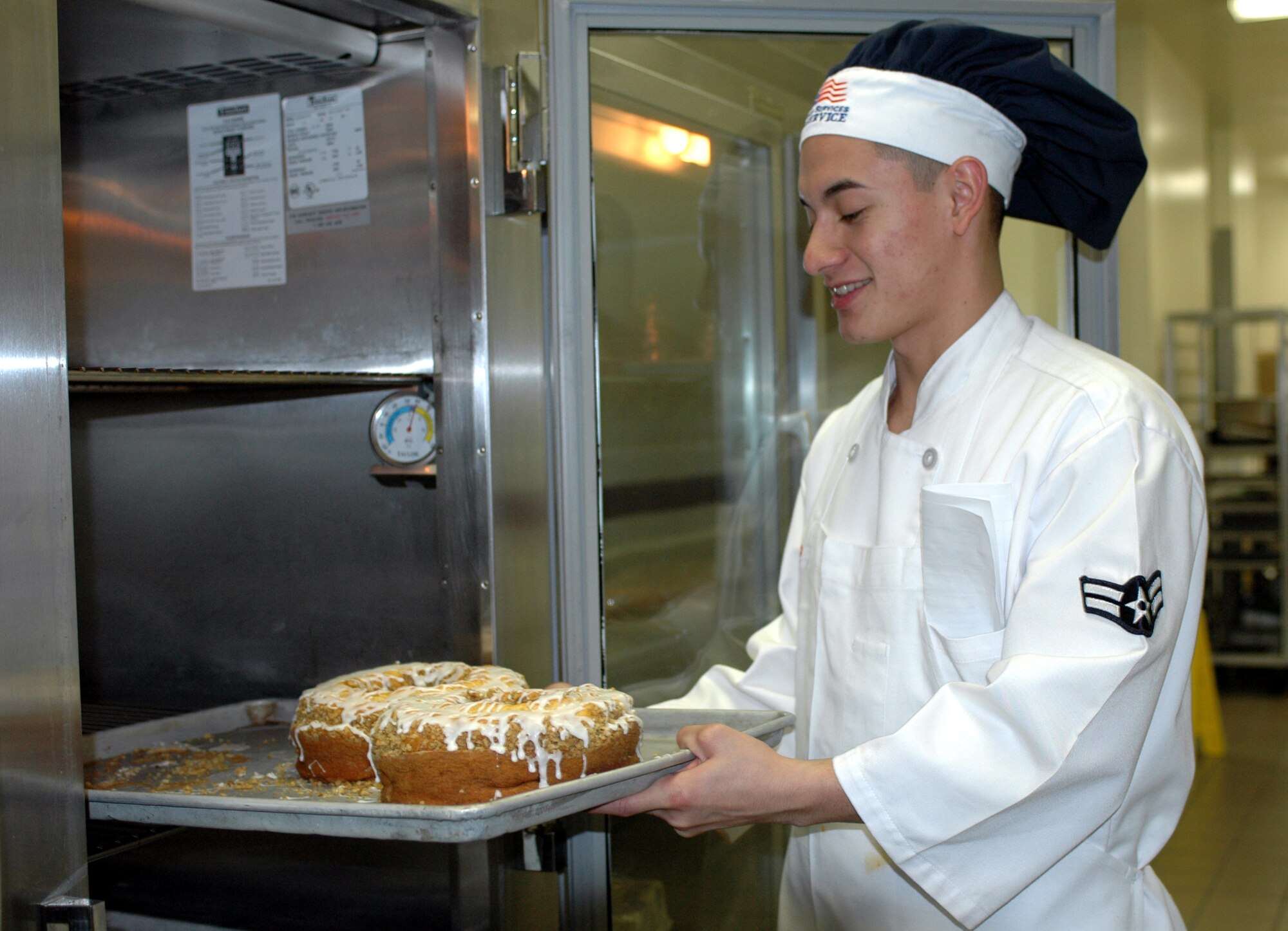 Airman 1st Class Bryon Larrea removes freshly baked pastry from it cooling shelf. The 60th Services Squadron’s Food Service Flight is preparing for the 2007 Air Force Hennessy Award competition. (U.S. Air Force photo by Staff Sgt. Candy Knight)