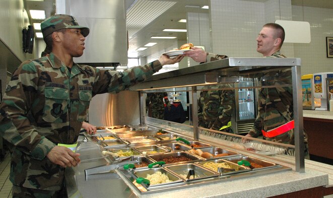 Airman Rayshawn Fountaine, 374th Services Squadron food service specialist, serves up lunch to another Airman at the Samurai Cafe Tuesday. The dining facility is preparing for the John L. Hennessy competition which recognizes the best of the best food service operations throughout the Air Force. The Hennessy award is based on the entire scope of an installation's food service program to include exhibiting excellence in management effectiveness, force readiness support, food quality, employee and customer relations, resource conservation, training and safety awareness. The team will be conducting a review of the facility Feb. 26 and 27.
(Photo by Staff Sgt. Ruth Curfman)