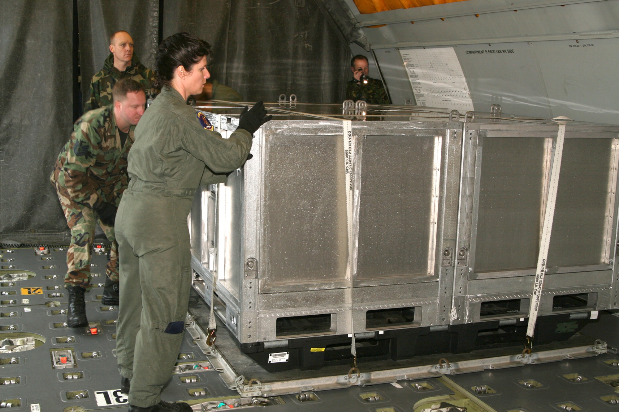 (From rear to front) Master Sgt. Richard Ratzer and Tech. Sgt. Adam Rich, 60th Aerial Port Squadron air transportation craftsmen, and Tech. Sgt. Christy Schultz, 9th Air Refueling Squadron boom operator, load and position a Joint Modular Inter-modal Container pallet onto a KC-10 cargo compartment. Team Travis hosted a Joint Modular Inter-Modal Distribution System Aircraft Loading Technical Demonstration Feb 8 and 9 to explore techniques and procedures that lessen problems and maximize loading and handling efficiency. (U.S. Air Force photo by Master Sgt. Wendy Weidenhamer)