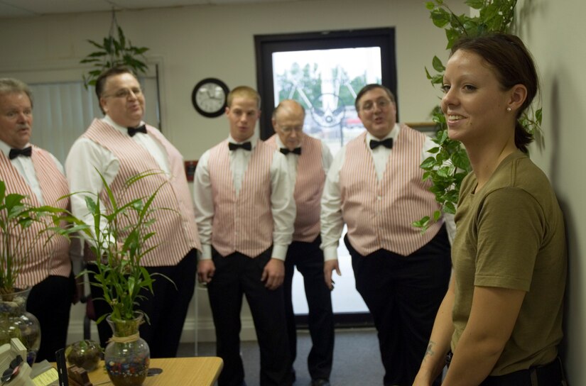 Senior Airman Meredith Hazel, 437th Civil Engineer Squadron, recieves a singing valentine from members of the Charleston Barbershop Chorus Tuesday at the CE complex. Airman Hazel's deployed boyfriend, Senior Airman Tyrone Greer, 437 CES, sent the singing valentine which included two love songs, a long-stemmed rose and  a card. (U.S. Air Force photo/Senior Airman Sam Hymas)