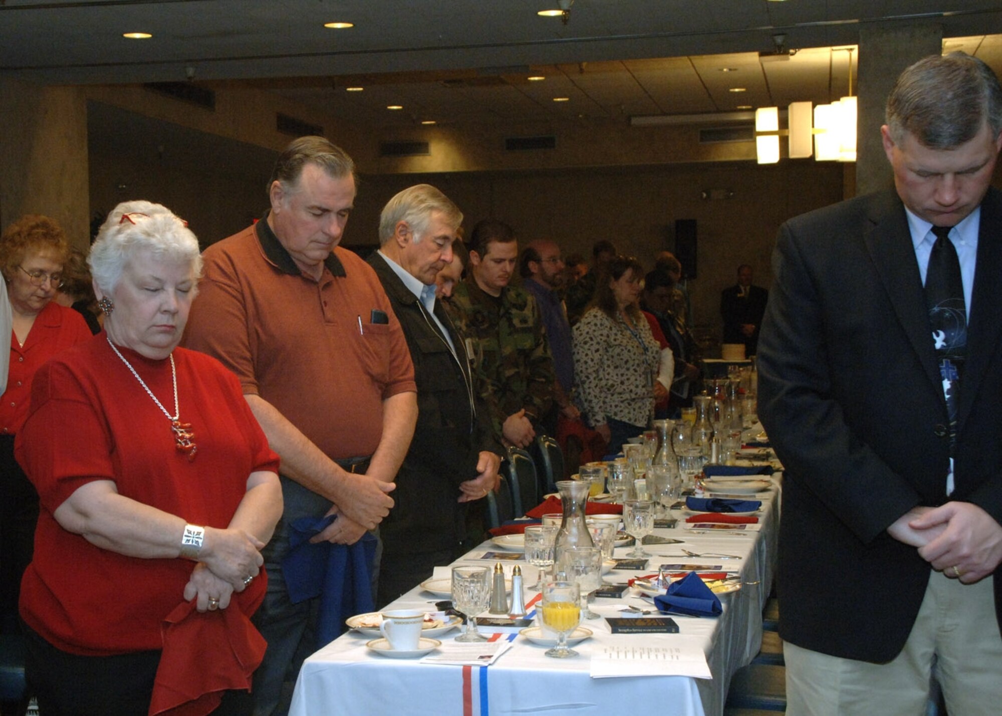 Members of the 49th Fighter Wing bow their heads in prayer during the annual National Prayer Breakfast here Tuesday.
