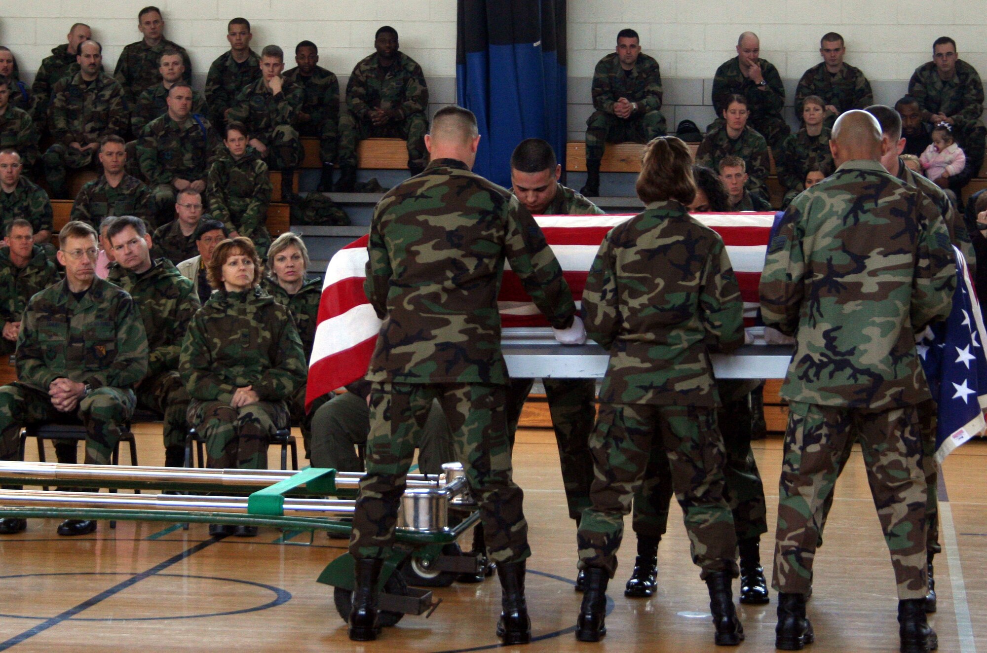 The six-man pallbearer team lowers a casket as Col. Lansen Conley, vice commander 82nd Training Wing, watches during the mock funeral held as part of the U.S. Air Force honor guards instruction team's visit Feb. 5 through Feb. 10. The instruction team was at Sheppard to teach local base honor guards how to perform full military honors. (U.S. Air force photo/Adrian McCandless)