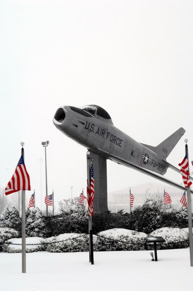 One of Hanscom’s static displays, an F-86 Sabre, ‘flies’ through the winter mix that blanketed the base Wednesday during a nor’easter. The Valentine’s Day weather postponed base readiness training and sent many employees home early. (US Air Force Photo by Mark Wyatt)