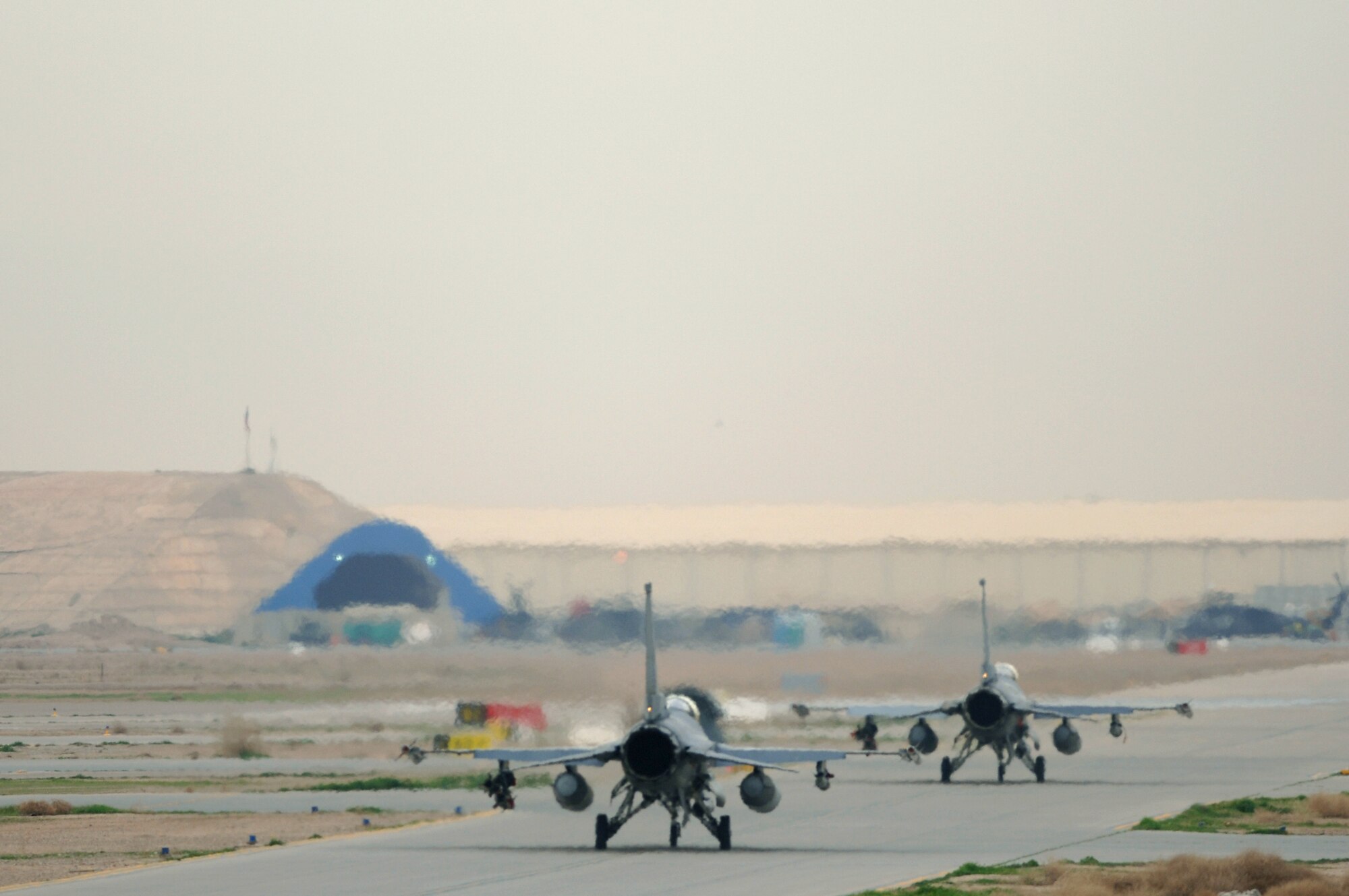 Two F-16 Fighting Falcons from the 510th Expeditionary Fighter Squadron taxi toward the runway for a mission Feb. 13 from Balad Air Base, Iraq. The 510th FS is deployed from Aviano Air Base, Italy. These missions involve flying close-air support to support coalition troops, infrastructure protection, reconstruction activities and operations to deter and disrupt terrorist activities. (U.S. Air Force photo/Staff Sgt. Michael R. Holzworth)