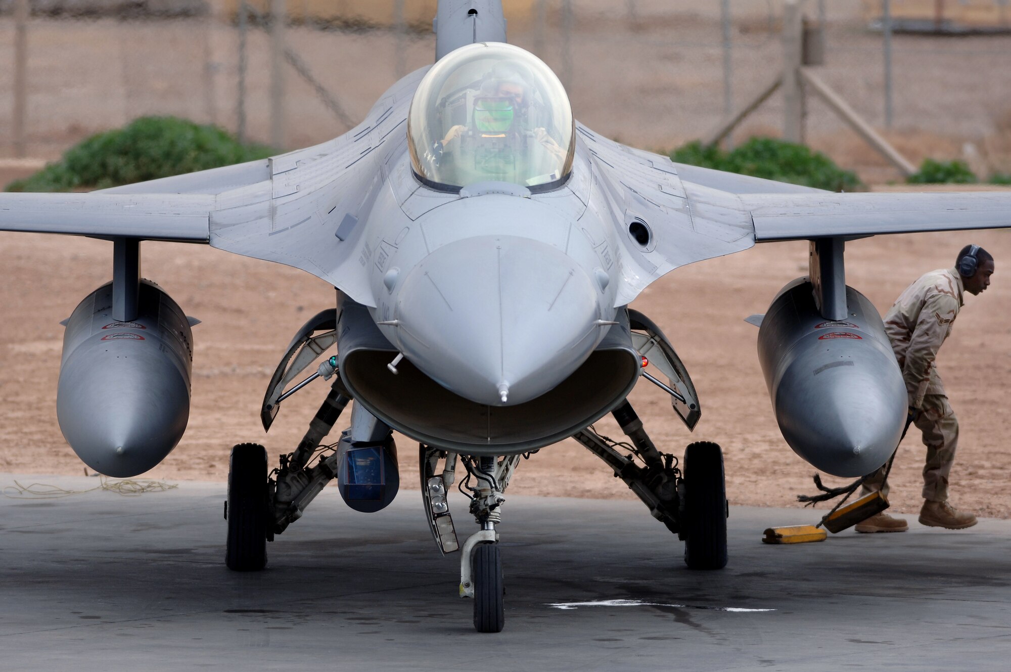 Airman 1st Class Stephen Tyler pulls the chocks and moves away from an F-16 Fighting Falcon before a mission Feb. 13 from Balad Air Base, Iraq. Airman Tyler is assigned to the 332nd Expeditionary Aircraft Maintenance Squadron from Aviano Air Base, Italy. (U.S. Air Force photo/Staff Sgt. Michael R. Holzworth)
