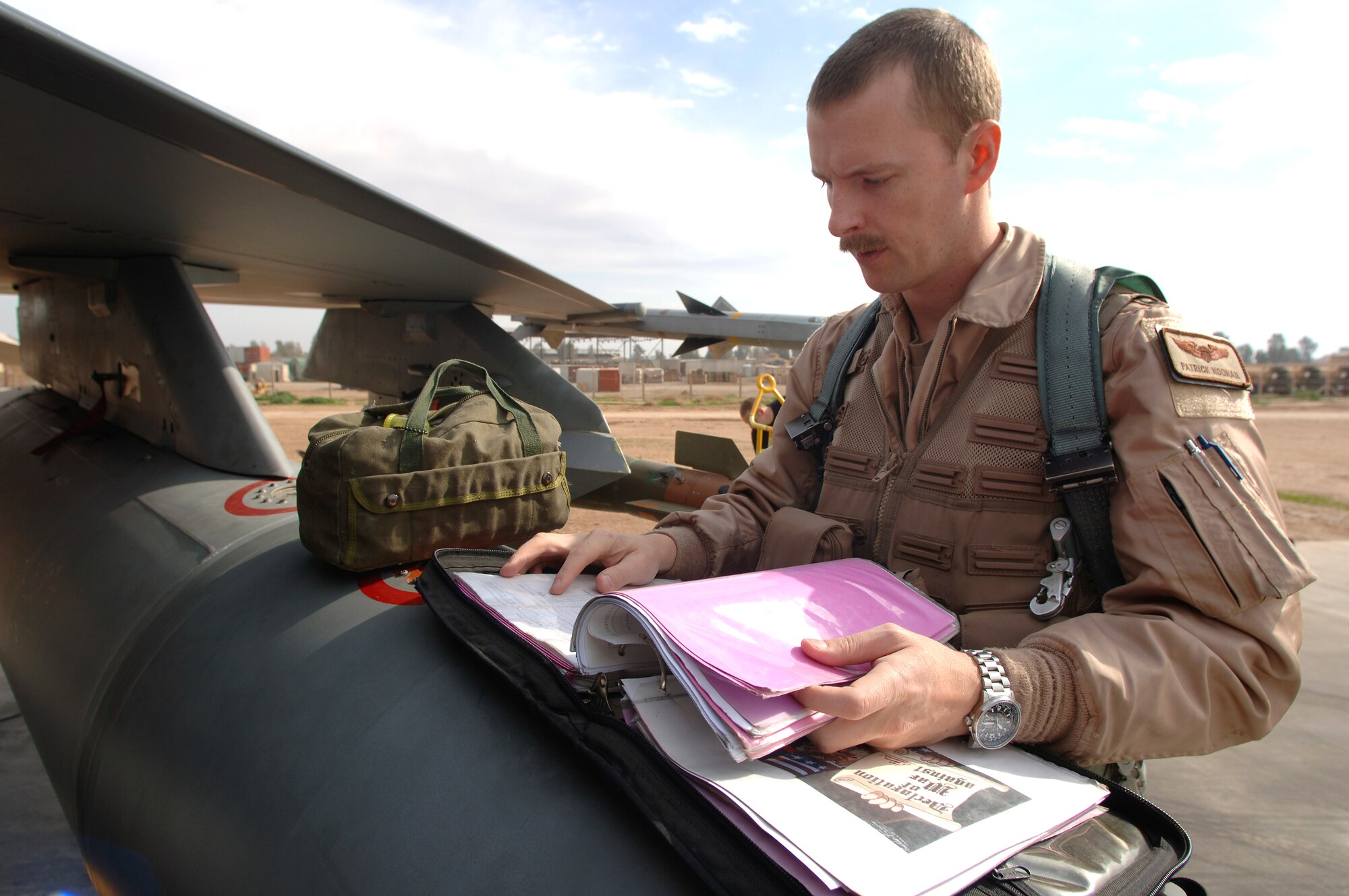 Capt. Patrick Noonan goes over a pre-flight checklist before departing in an F-16 Fighting Falcon on a Operation Iraqi Freedom mission Feb. 13 from Balad Air Base, Iraq. Captain Noonan is deployed to the 510th Expeditionary Fighter Squadron from Aviano Air Base, Italy. These missions involve flying close-air support to support coalition troops, infrastructure protection, reconstruction activities and operations to deter and disrupt terrorist activities. (U. S. Air Force photo/Staff Sgt. Michael R. Holzworth)

