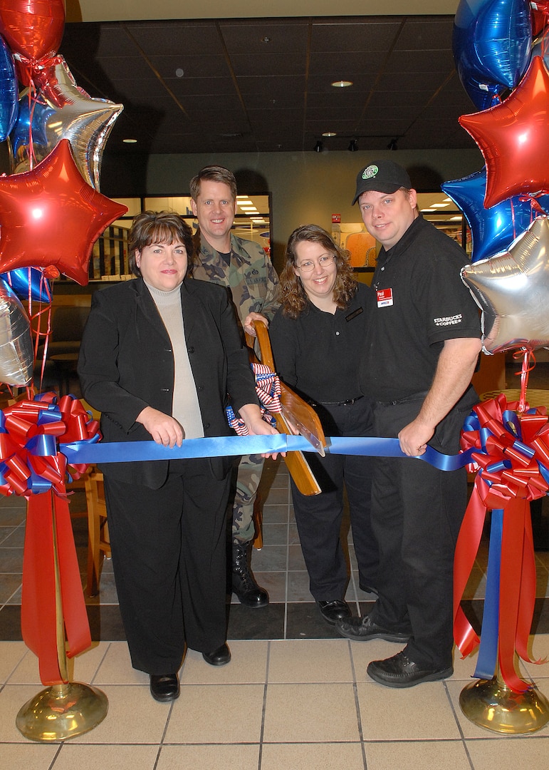 Julie Cosby, manager of the Army and Air Force Exchange Service's San Antonio Exchange (left), Col. Eric Wilbur, 37th Training Wing vice commander at Lackland Air Force Base, Texas, Lori Maggard, AAFES Basic Military Training senior food mall manager, and Paul Claxton, BMT concept food manger, officially open Lackland's Starbucks Feb. 14 by the ceremonial cutting of the ribbon. Approximately 50 people attended the opening event. Located in the Basic Military Training Food Mall, Bldg. 7025, Starbucks will be open Monday-Friday from 6 a.m. to 8 p.m., and Saturday and Sunday from 7 a.m. to 8 p.m. Patrons who bring their own coffee mug will receive 10 cents off their purchase. (USAF photo by Robbin Cresswell)
