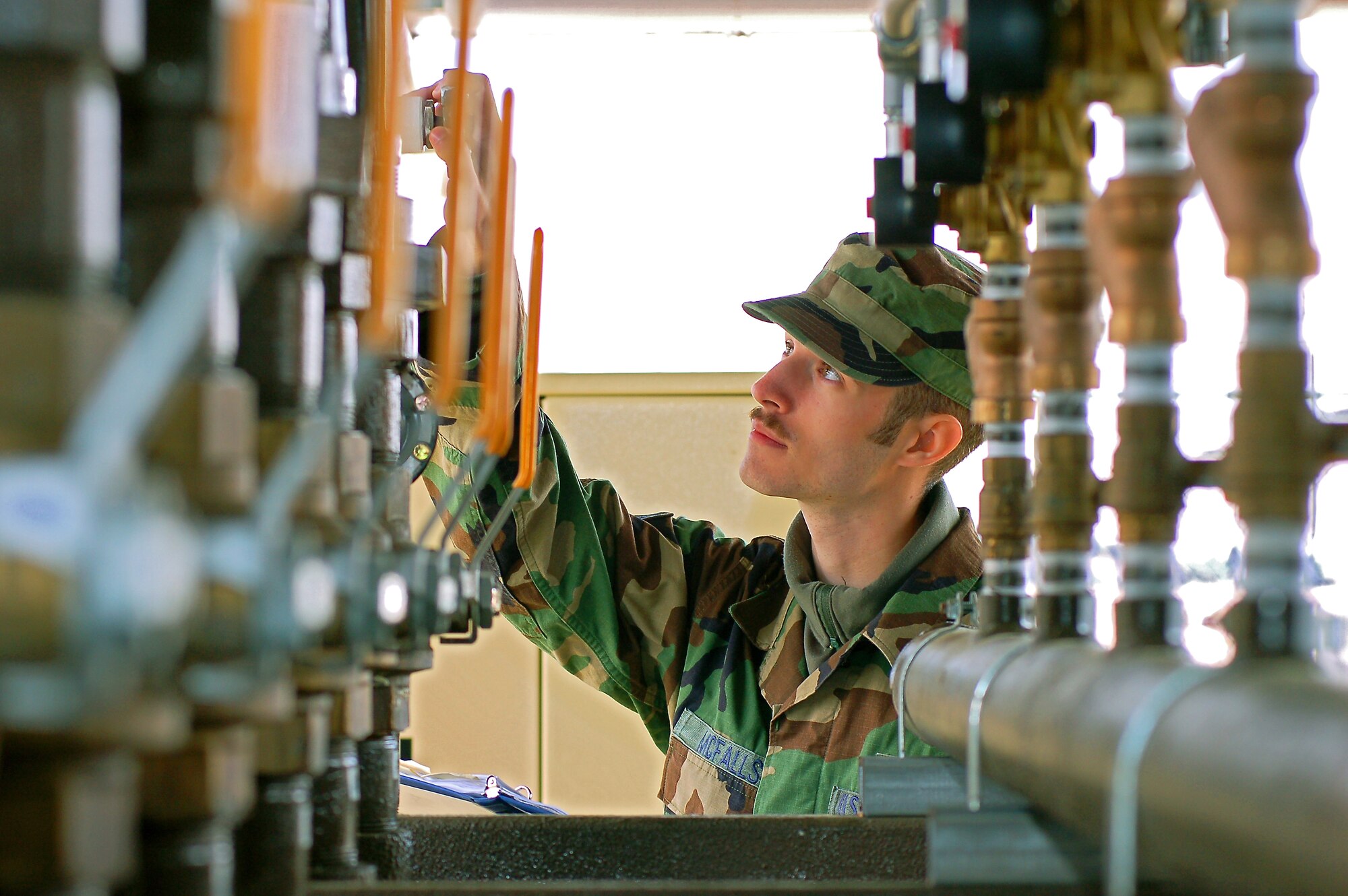 Senior Airman Steven McFalls, 23rd Civil Engineer Squadron liquid fuels journeyman, checks a valve during a safety inspection here recently. The mixing plant is capable of providing 10 days of gas to the base during winter consumption rates without resupply.   (U.S. Air Force photo by Tech. Sgt. Parker Gyokeres)
