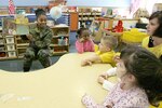 Tech. Sgt. Tanesha Lucas, 341st Recruiting Squadron, reads to a group of 3-5 year olds in Luann Ball's yellow room at the Lackland Child Development Center on Lackland Air Force Base, Texas. Sergeant Lucas was one of eight volunteers who spent an hour Feb. 13 reading to children in various classes in the three CDCs on base. The event was organized by the African-American Heritage Committee in honor of African-American History Month. (USAF photo by Robbin Cresswell) 