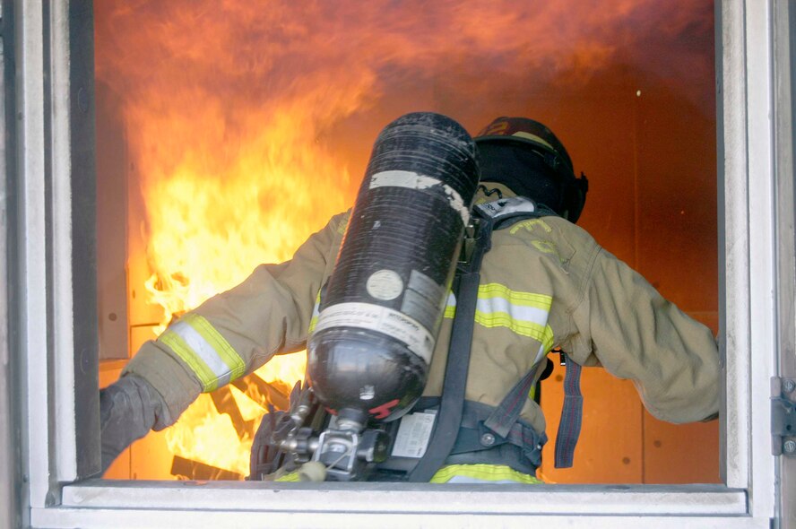 Staff Sergeant Brian Hill, 90th Civil Engineer Squadron, avoids flames after entering the fire department's live-fire training building on base Jan. 24, 2007.  The fire department conducts monthly live-fire training and structural exercises.