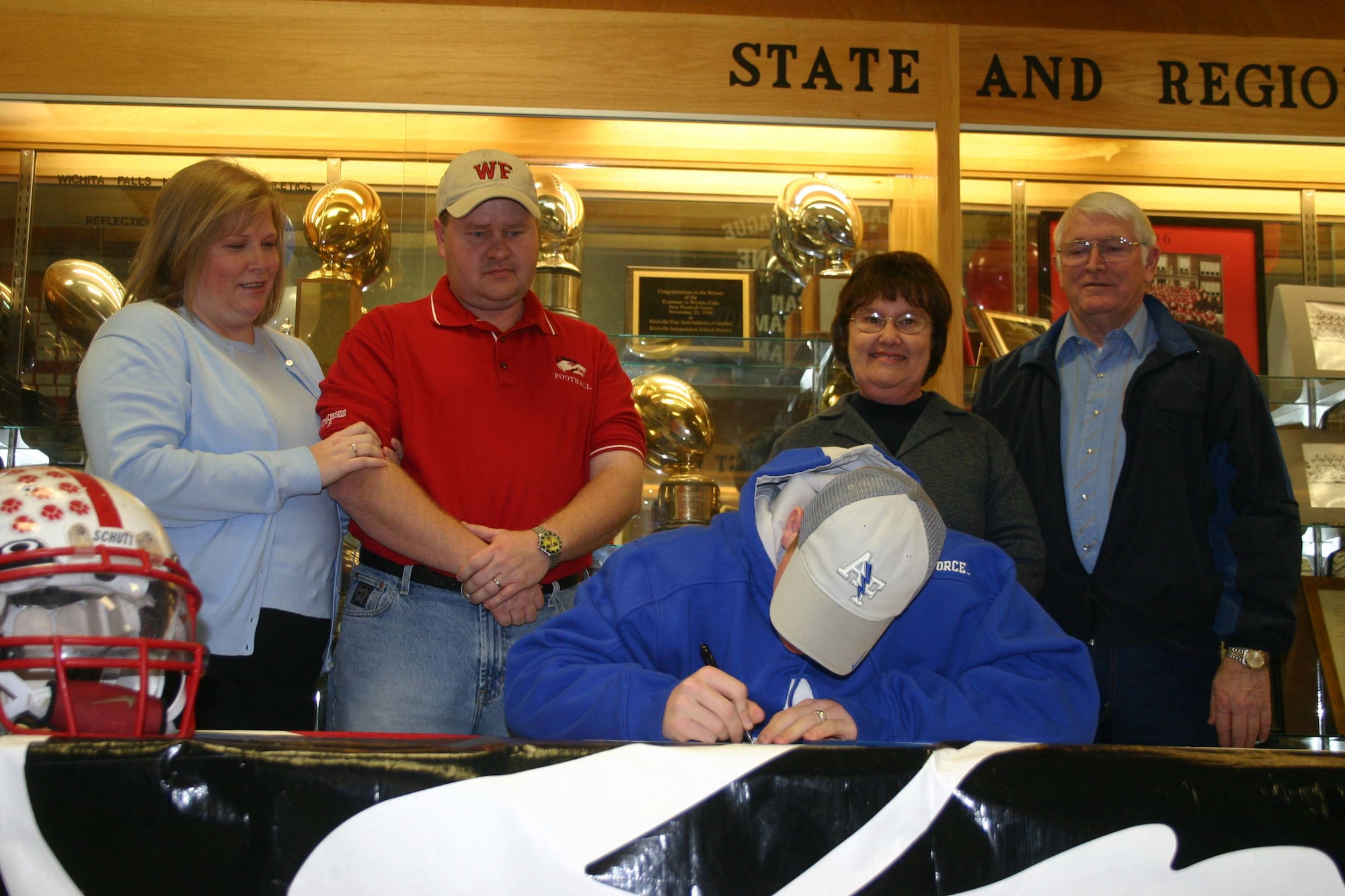 Taylor Huskisson signs up to become the newest Air Force Academy cadet at Wichita Falls Senior High School Feb. 7.  Looking on are mother Shenna, father Shawn, grandmother Yvonne and grandfather Glen Huskisson. (U.S. Air Force Photo/Staff Sgt. Tonnette Thompson)