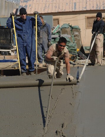 Airman 1st Class Steven Fernandez (front), Airman 1st Class James McFarland (left), Senior Airman Avery Bahe (back), and Senior Airman Tyrone Greer (right), from the 455th Expeditionary Civil Engineer Squadron, place concrete for a new facility at Bagram Airfield, Afghanistan, Feb. 14.