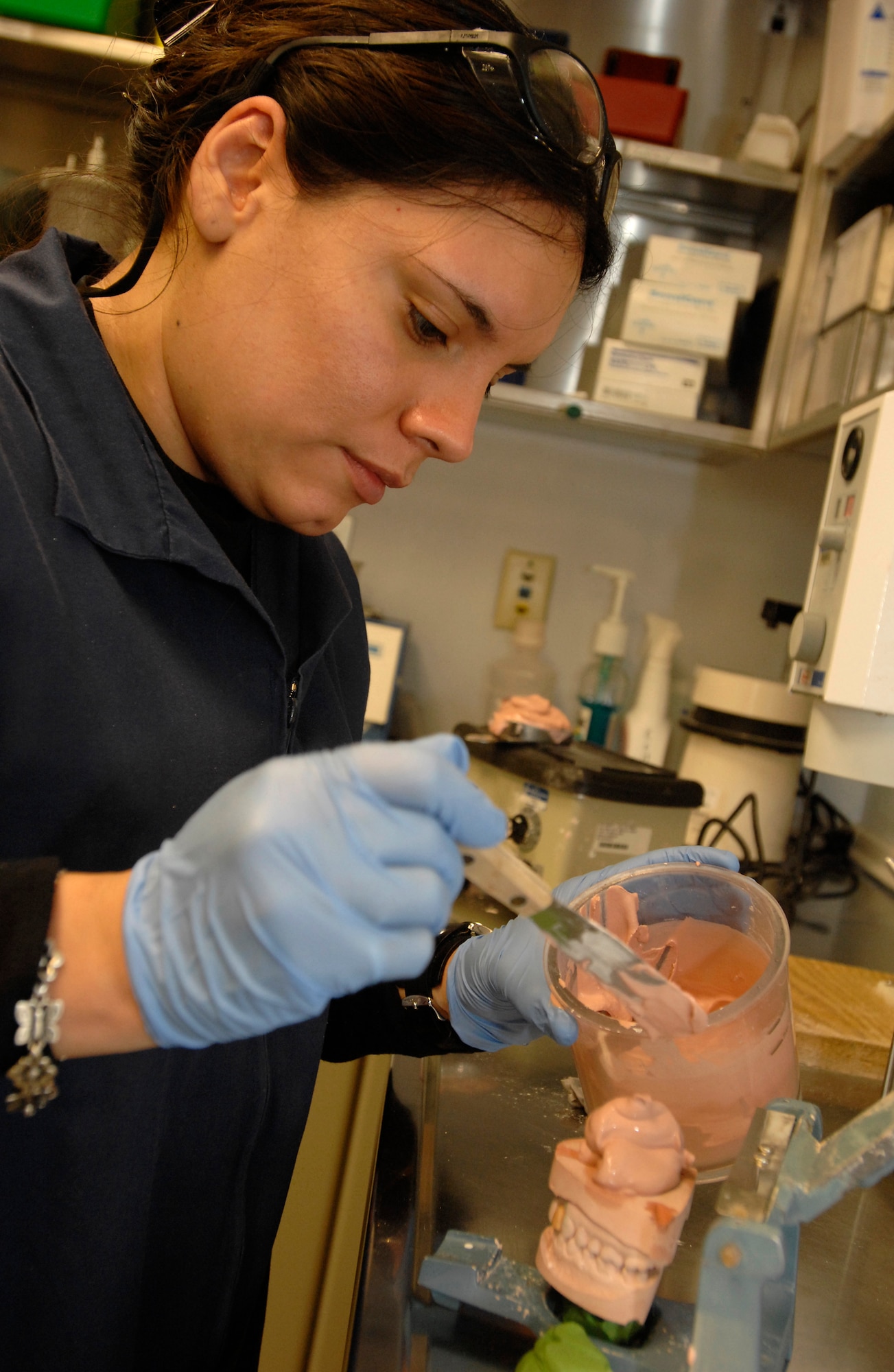 Staff Sgt. Violeta Olivo, 31st Dental Squadron lab technician, applies a stone base to casts to keep them on the articulator, which simulates the patients natural jaw movement.  (Photo by Airman 1st Class Liliana Moreno)