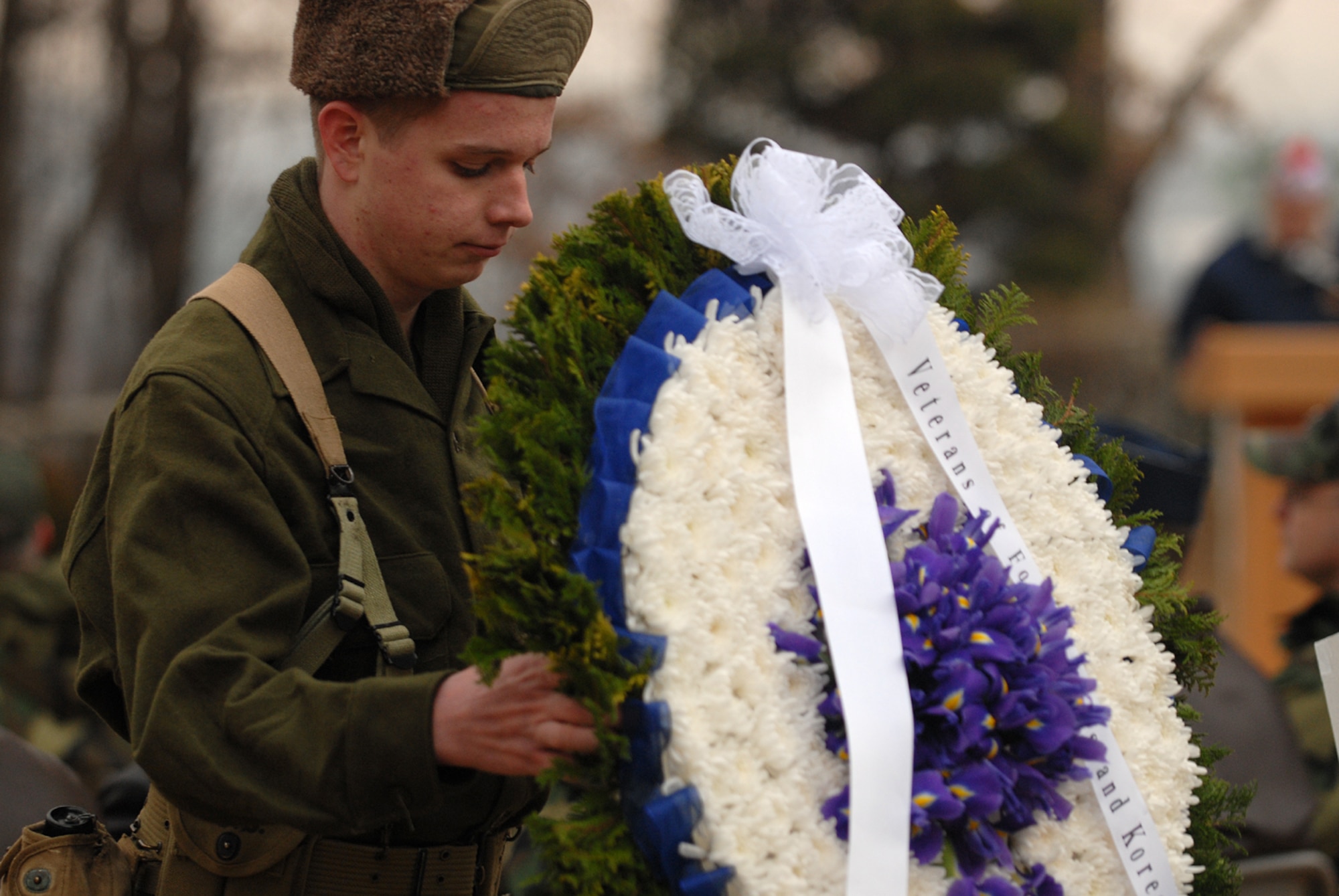 Robert Carter, a member of the Osan American High School Junior ROTC program, moves one of four wreaths that were placed during the Hill 180 ceremony Feb. 9. (U.S. Air Force photo by Airman Jason Epley)