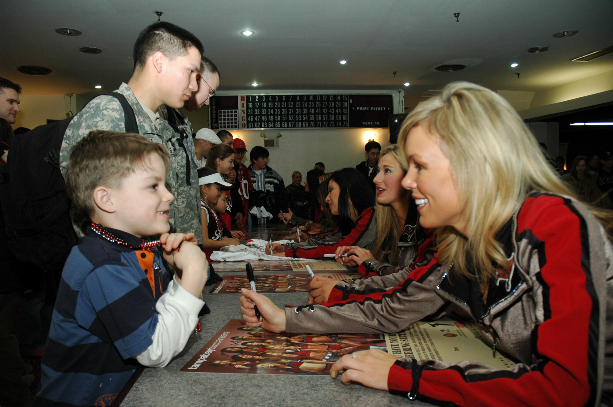 OSAN AIR BASE, Republic of Korea --  Tampa Bay Buccaneers cheerleader Catherine Croake signs an autograph for Trey Hayenga following the cheerleaders’ Appreciation Tour 2007 Feb. 14 at the Challenger Club here. The show consisted of various dance and cheer routines followed by a meet-and-greet autograph session with all the cheerleaders. (U.S. Air Force photo by 1st Lt. Kevin Coffman)