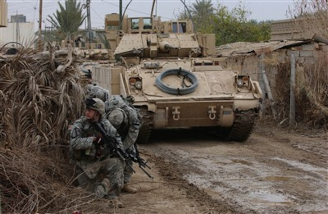 U.S. Army soldiers with Bravo Company, 3rd Battalion, 8th Cavalry Regiment wait for orders to conduct a house search for weapons caches near Contingency Operating Base Speicher, Iraq, on Feb. 10, 2007.  