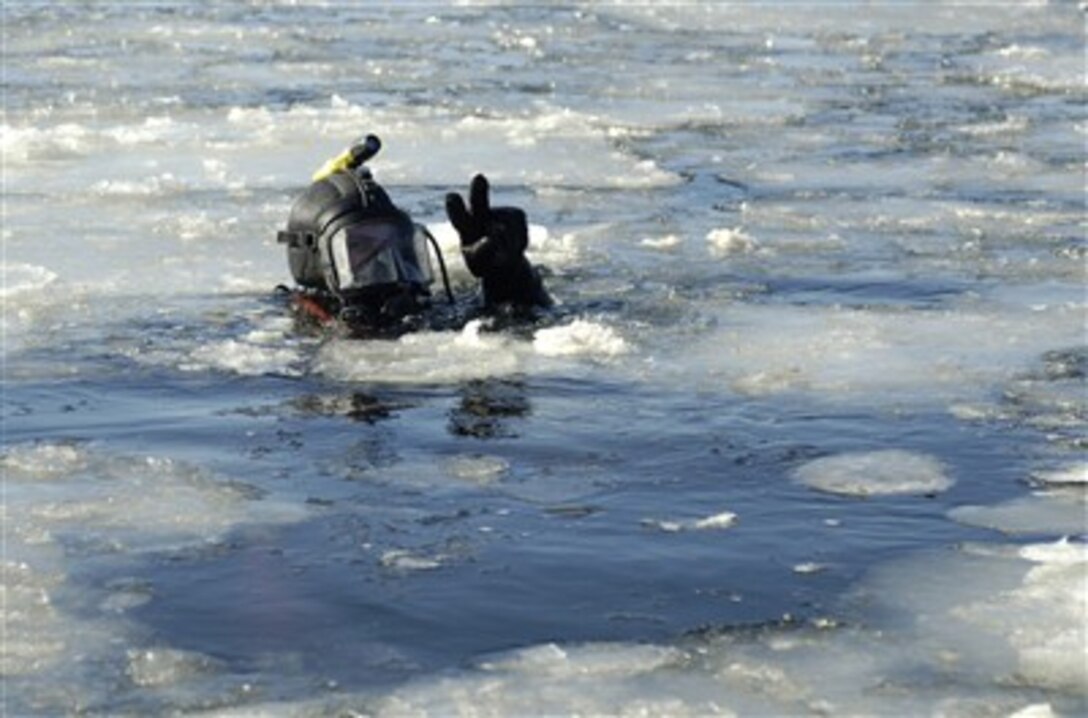 U.S. Navy Diver Petty Officer 3rd Class John Seagraves signals that he is okay during a training mission in the icy Thames River at Submarine Base New London in Groton, Conn., on Feb. 7, 2007.  