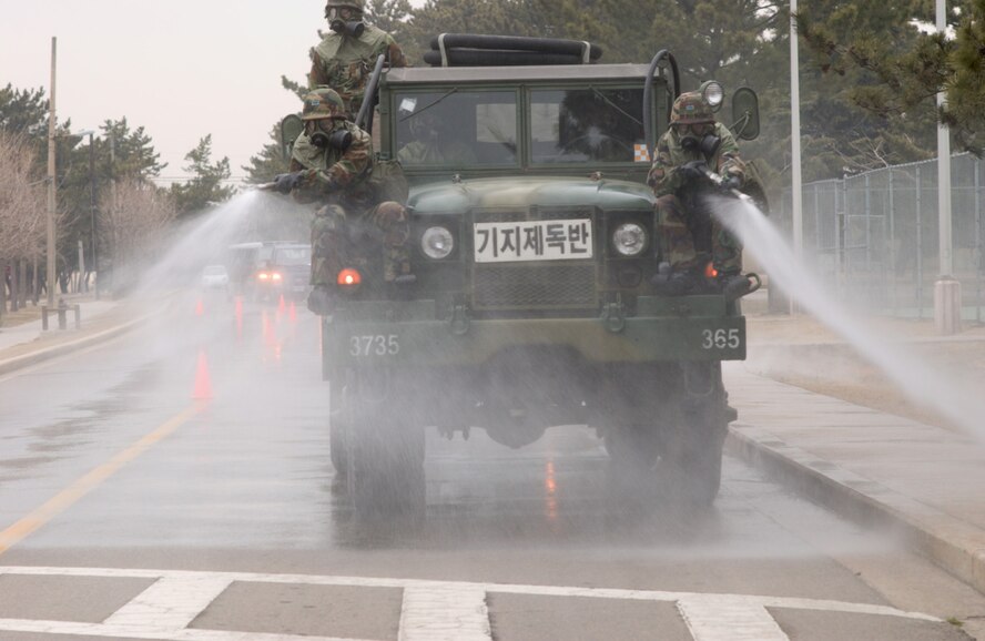 KUNSAN AIR BASE, Republic of Korea Feb. 13, 2007 -- Republic of Korea servicemembers simulate terrain decontamination procedures during a joint decontamination exercise conducted near the base's track Feb. 13. The exercise was conducted between U.S. and Republic of Korea servicemember to practice, evaluate and improve decontamination procedures in a chemical enviroment. (Air Force photo by Senior Airman Barry Loo)