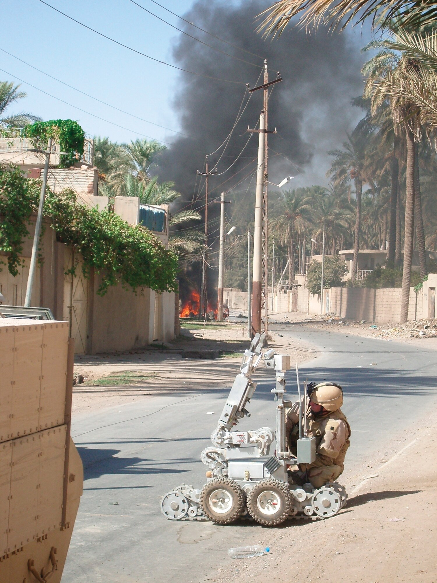 SOUTHWEST ASIA ? Senior Airman Kyle Preece, 332nd Expeditionary Civil Engineer Squadron Explosive Ordnance Disposal flight, works on a F6A robot recently as a vehicle-borne improvised explosive device burns in the background.
(U.S. Air Force photo)
