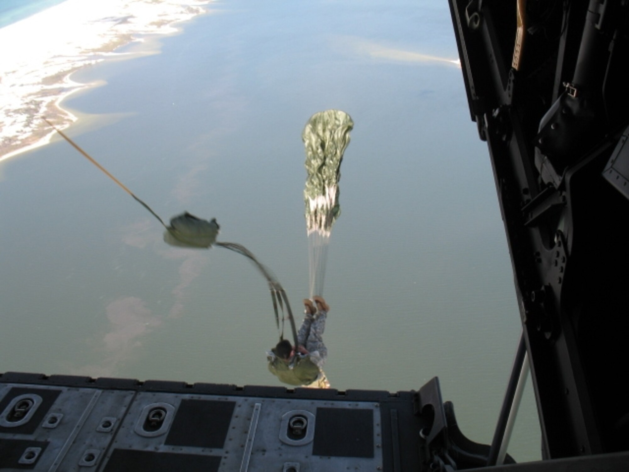 A Joint Ground Liaison student performs a static line jump from an MC-130 into the Gulf of Mexico. (Photo by Chief Warrant Officer Todd Sowerby.)