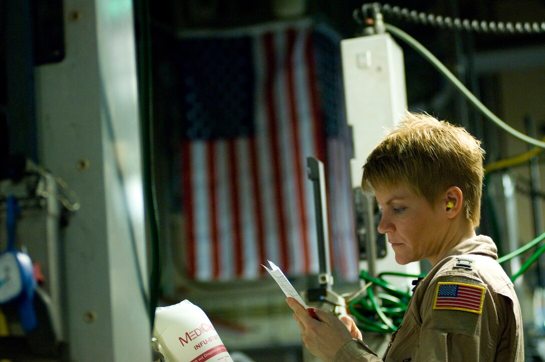 Capt. Jacqueline Cole monitors the condition of a critical-care patient Feb. 14 while traveling on a C-17 Globemaster III from Balad Air Base, Iraq, to Landstuhl, Germany, where he will receive further care for his wounds. Captain Cole is a member of the Critical Care Air Transport Team assigned to the 332nd Expeditionary Operations Group. (U.S. Air Force photo/Tech. Sgt. Cecilio M. Ricardo Jr.)