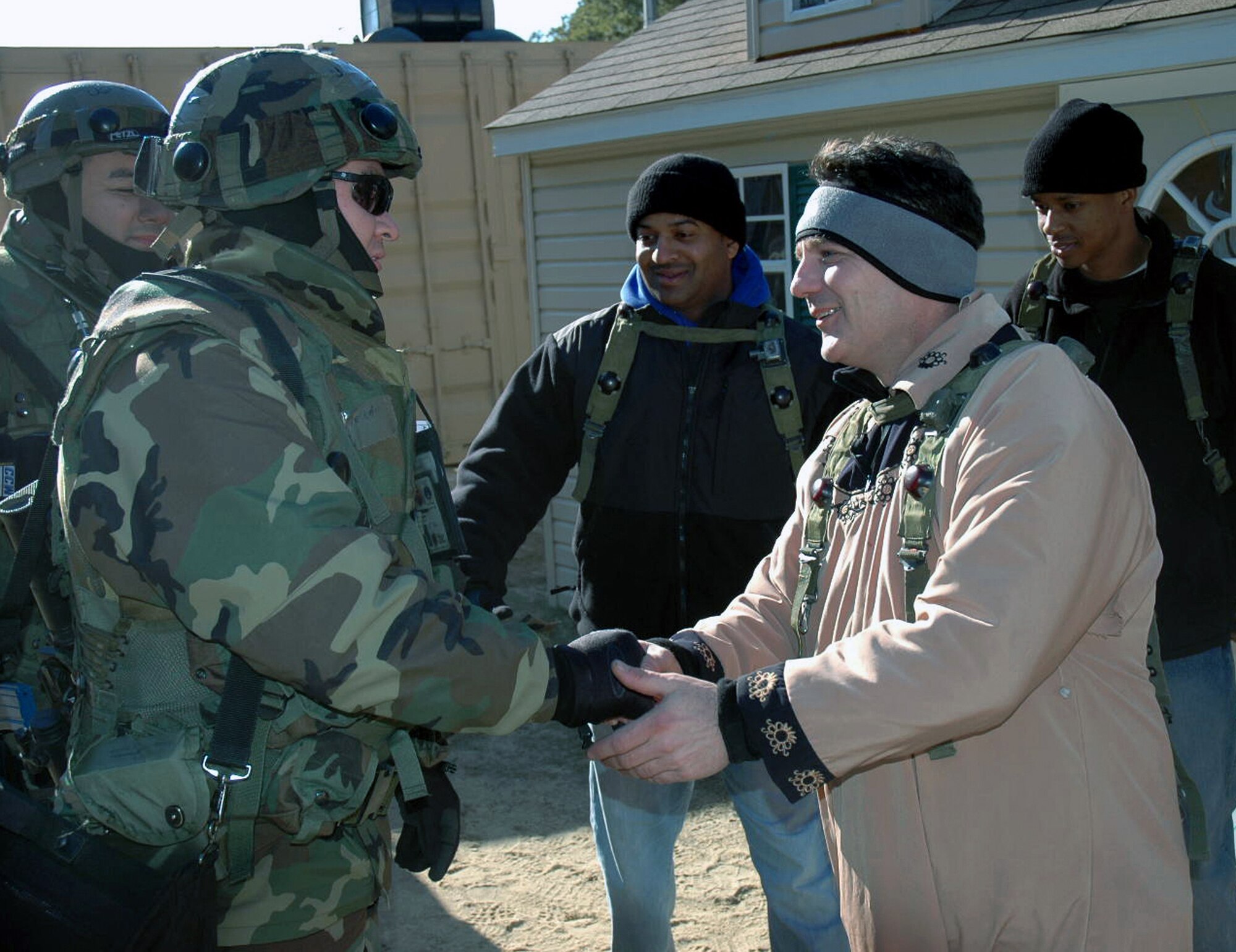 Airmen deployed as part of Air Force Exercise Eagle Flag 07-3 shake hands during a planned scenario in "Citheron" village Feb. 11 at Naval Air Engineering Station Lakehurst, N.J. The exercise, operated by the Air Mobility Warfare Center's 421st Combat Training Squadron, tests and trains more than 400 Airmen on their expeditionary combat support skills. (U.S. Air Force photo/Tech. Sgt. Ron Rogers) 