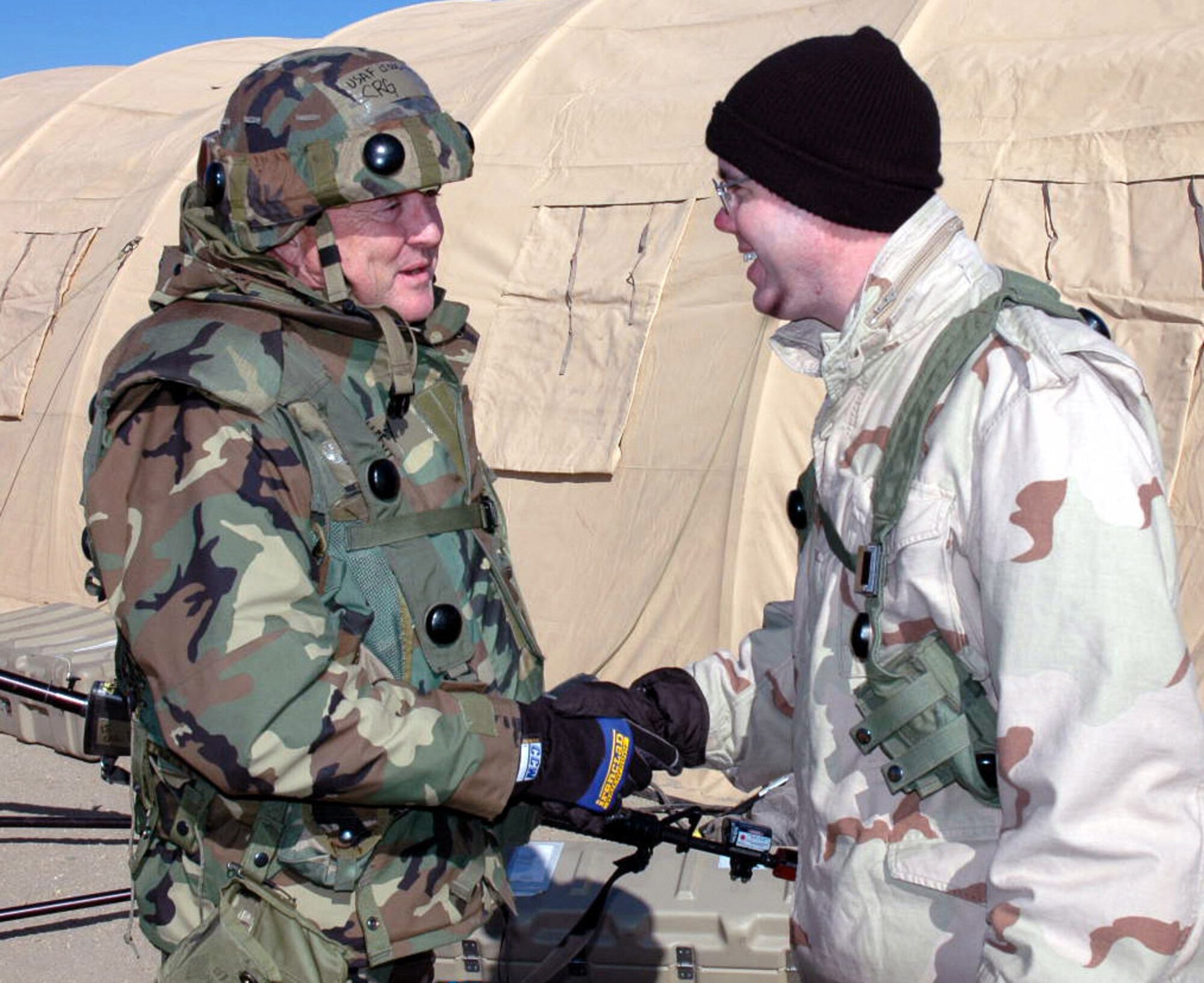 Airmen deployed as part of "421st Air Expeditionary Group" and the mock "National Army of Chimaera" shake hands while meeting for the first time in a scenario during operations for Exercise Eagle Flag 07-3 Feb. 10 at Naval Air Engineering Station Lakehurst, N.J. The exercise, operated by the Air Mobility Warfare Center's 421st Combat Training Squadron, tests and trains more than 400 Airmen on their expeditionary combat support skills. (U.S. Air Force photo/Tech. Sgt. Ron Rogers) 