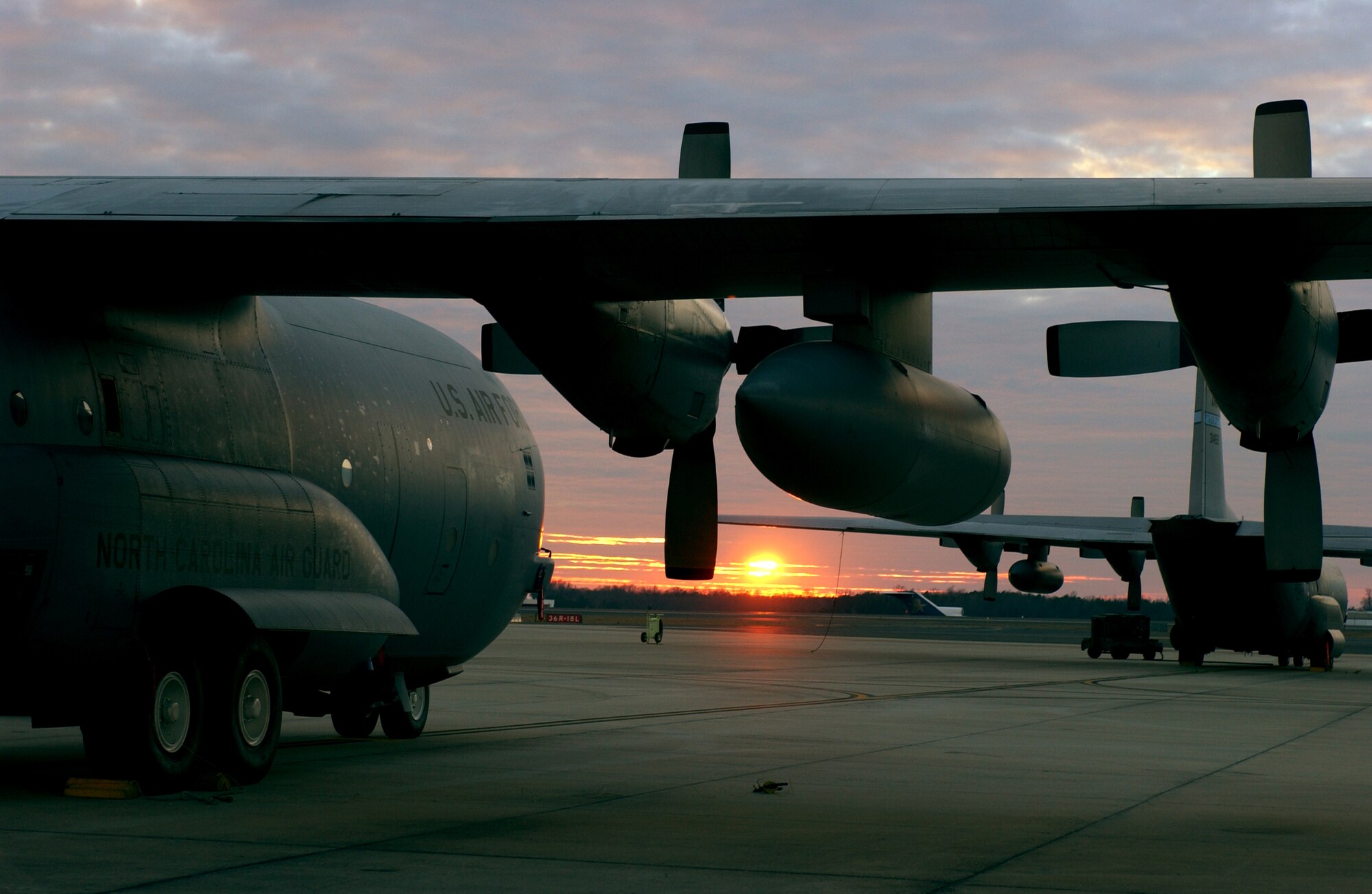 C-130 Hercules aircraft sit on the flightline during the sunset Feb. 6 at Charlotte, N.C. Several 145th Airlift Wing North Carolina Air Guard aircraft and Airmen are deploying to support Operation Enduring Freedom.  The C-130 can accommodate a wide variety of oversized cargo, including everything from utility helicopters and six-wheeled armored vehicles to standard palletized cargo and passengers. (U.S. Air Force photo/Tech. Sgt. Brian E. Christiansen) 
