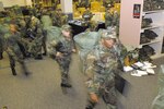 New basic military trainees rush through Initial Clothing Issue at Lackland Air Force Base, Texas, to get everything from boots to hats to battle dress uniforms. Under the old system (shown here), the trainees were issued, then changed into, their BDUs before leaving the facility. Under the new system, trainees change into their physical readiness uniforms instead while collecting their new wardrobe. Changing into PRUs and athletic shoes - instead of button-heavy BDUs and combat boots - has helped save an average of 20 minutes per flight.  (USAF photo by Robbin Cresswell)