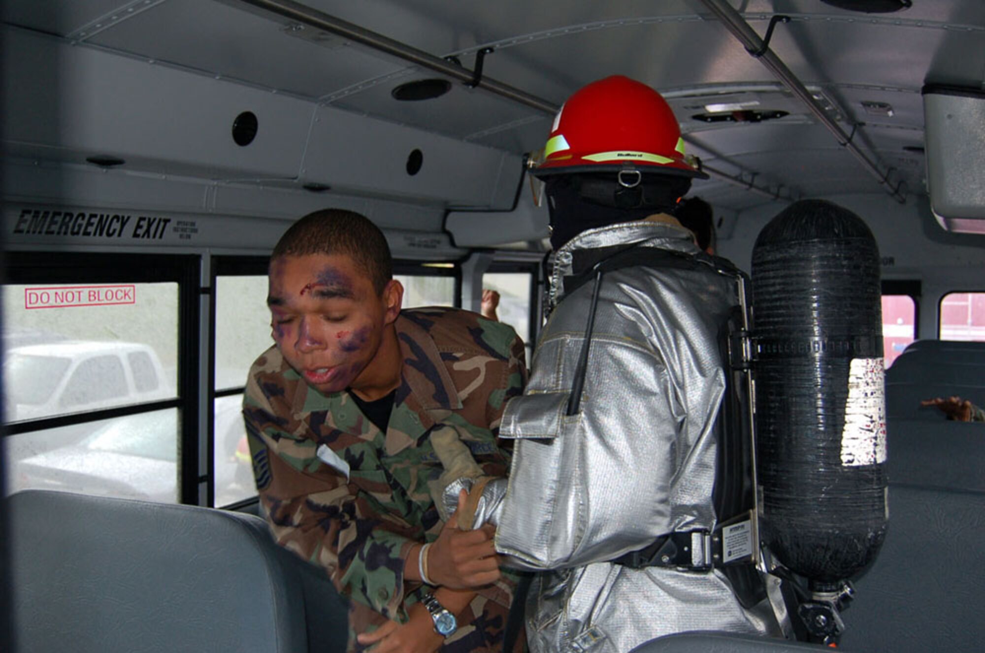 SPANGDAHLEM AIR BASE, GERMANY -- An exercise volunteer plays the role of an accident victim on the bus. A Spangdahlem fire fighter assists, him as he ensures all bus passengers are moved to safety so they can receive needed medical care.   (US Air Force photo by Senior Airman Eydie Sakura)