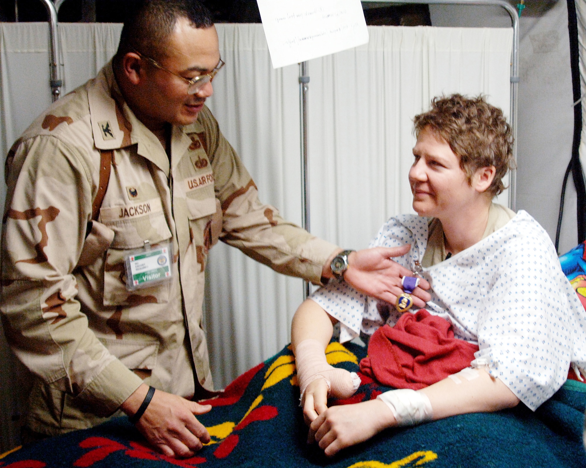 BALAD AIR BASE, Iraq -- Staff Sgt. Kathryn Robinson receives her Purple Heart medal from Col. Lawrence Jackson II, 732nd Expeditionary Mission Support Group commander, for wounds received from small arms fire.  Sergeant Robinson was on a cordon and search rescue mission with the military transition teams and Iraqi Army near Baqubah when she was struck by a sniper's bullet in the left forearm and the upper right thumb Feb. 10.  Sergeant Robinson is assigned to the 4th Combat Camera Squadron, March Air Reserve Base, Calif.  (U.S. Air Force Photo/Senior Airman Candace Romano)