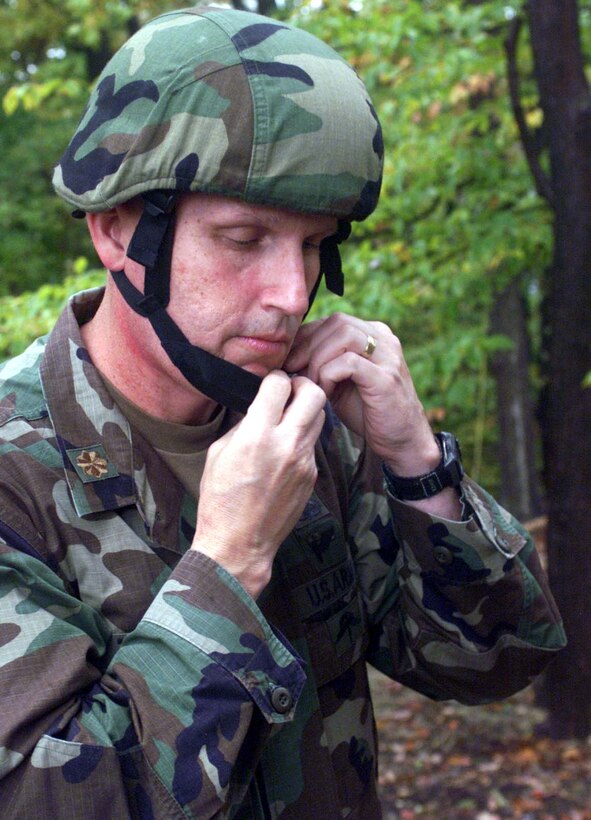 Army Maj. Scott A. Tyler, executive officer, Program  Executive Office Soldier at Fort Belvoir, Va., demonstrates the new helmet that  works with the new Interceptor body armor being used by soldiers and Marines in  Iraq and Afghanistan. Photo by Rudi Williams