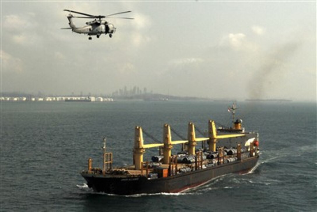 A U.S. Navy HH-60H Seahawk helicopter assigned to the "Eightballers" of Helicopter Anti-Submarine Squadron 8 flies over the civilian merchant ship Union Alliance while the Nimitz-class aircraft carrier USS John C. Stennis, not shown, transits the Straits of Malacca near Singapore, Feb. 14, 2007.