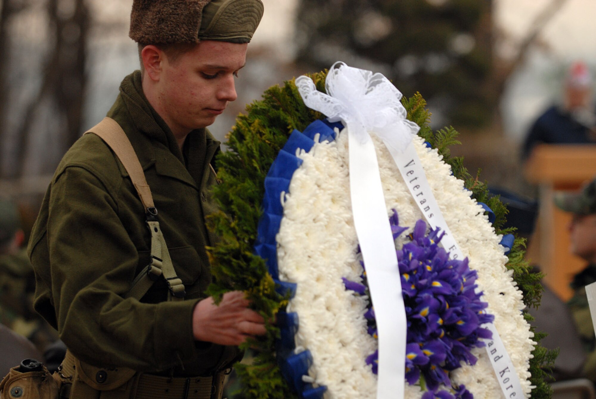 Robert Carter, a member of the Osan American High School Junior ROTC program, moves one of four wreaths that were placed during the Hill 180 ceremony Feb. 9. (U.S. Air Force photo/Airman Jason Epley) 
