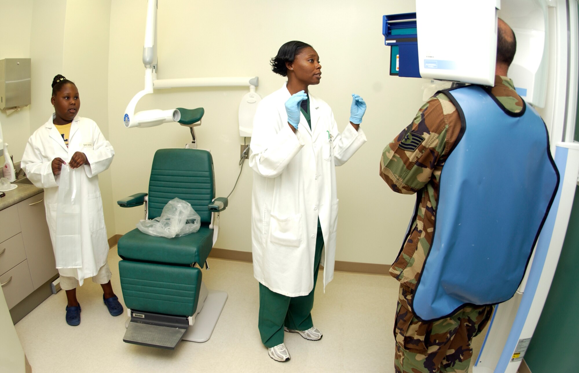 Tech. Sgt. Rebecca Nelson takes X-rays of a patient's teeth as her daughter Adrienne McCall, 10, watches on take your child to work day Feb. 6. Sergeant Nelson is a 36th Medical Operations Squadron NCOIC of clinical dentistry. (U.S. Air Force photo/Senior Airman Miranda Moorer)