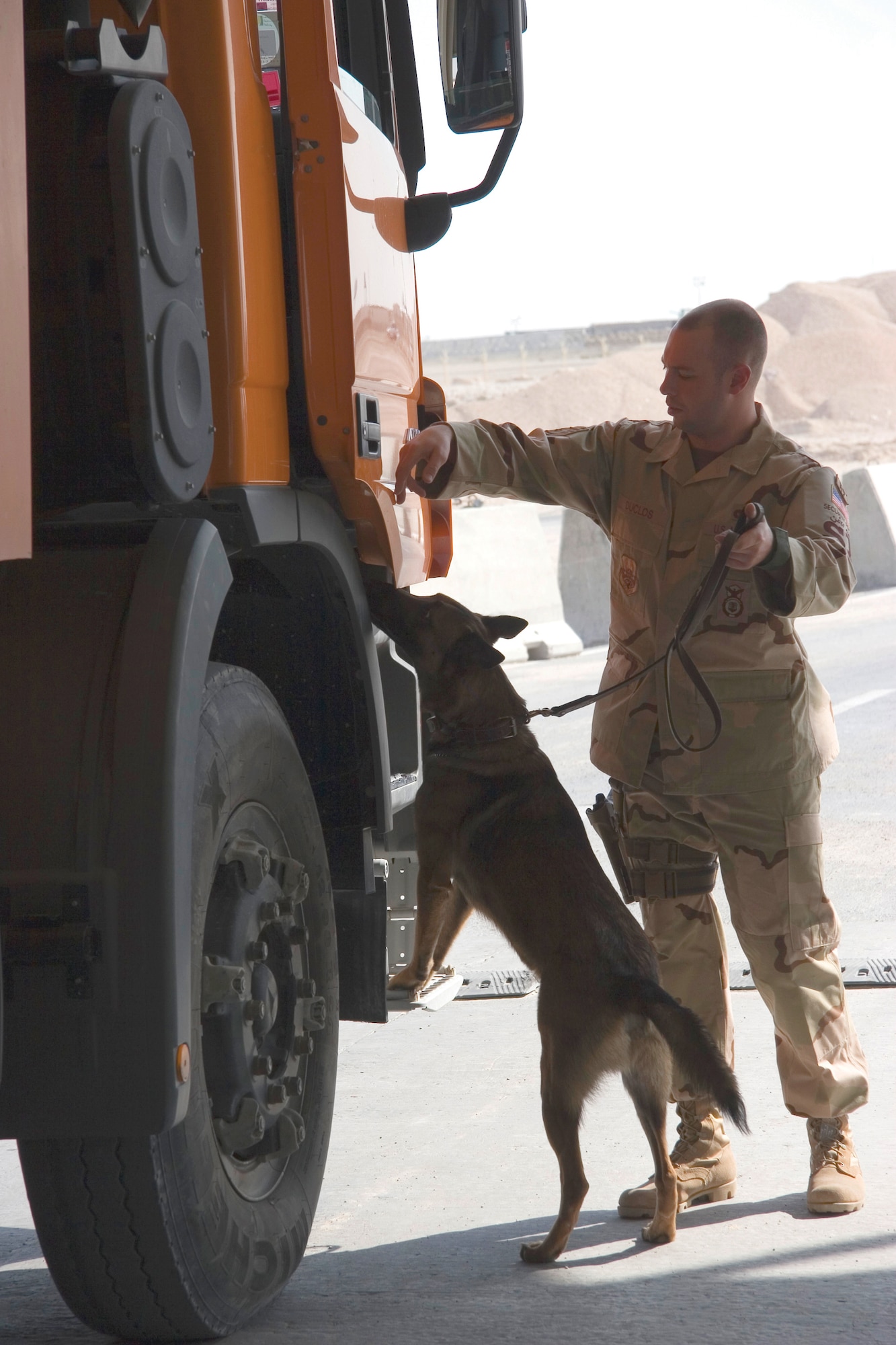 Staff Sgt. Spencer Duclos, 379th ESFS military working dog handler and element leader, conducts vehicle searches with his dog, Boo, at the vehicle search pit. (Photo by Tech. Sgt. Frank Hatcher)