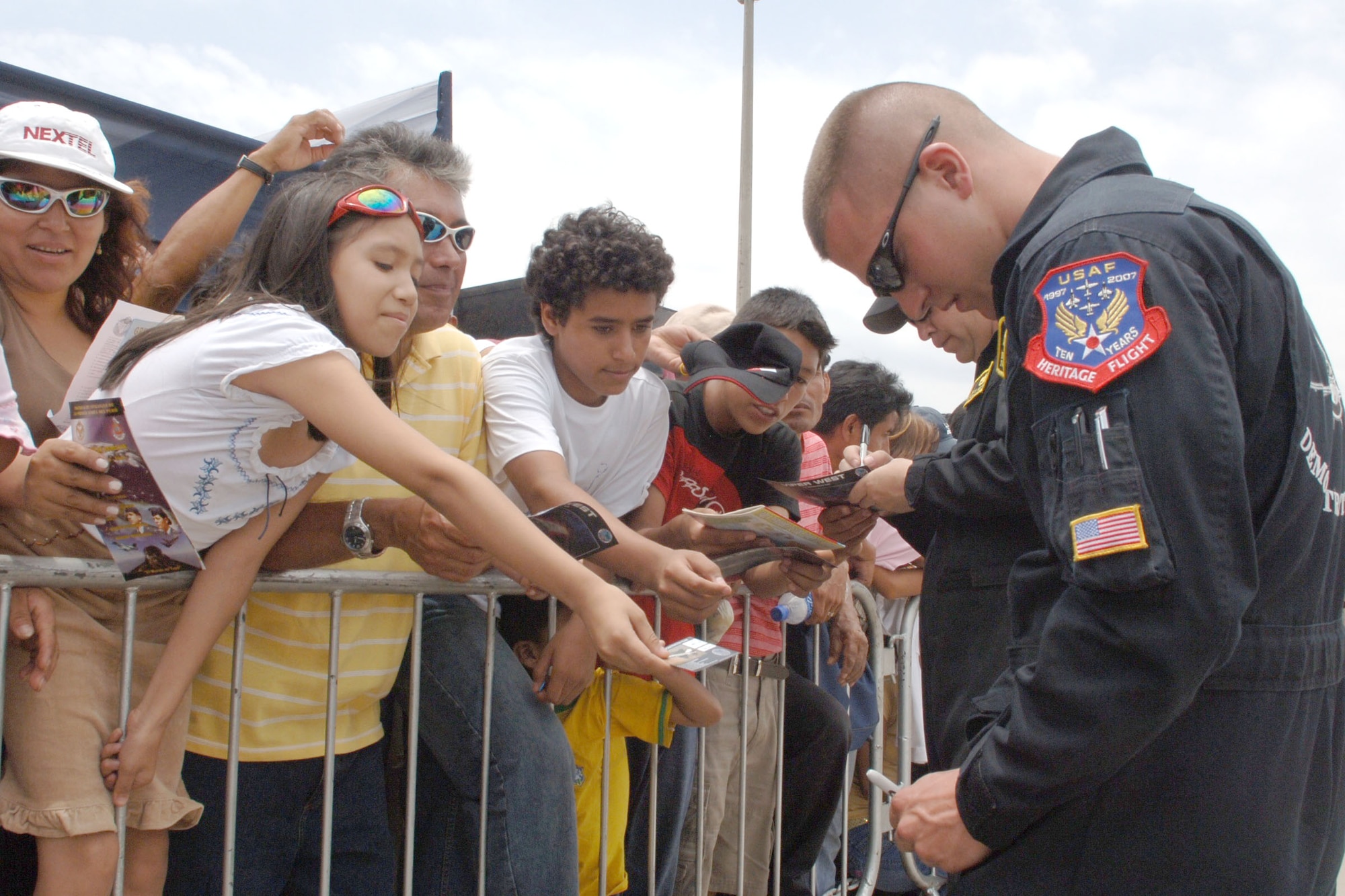 Senior Airman Arthur Greene autographs air show memorabilia Feb. 17 during Falcon Condor 2007, joint air show in Lima, Peru. The air show directly supports the U.S. Southern Command's engagement goals and furthers relations between allied nations. Airman Greene is a crew chief with the Air Combat Command's Viper West Demonstration Team. (U.S. Air Force photo/Tech. Sgt. Kerry Jackson)