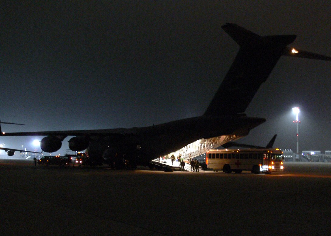Airmen from the 435th Aeromedical Staging Flight at Ramstein Air Base, Germany, unload 11 critically injured patients from an arriving C-17 Globemaster III. The injured troops had survived a helicopter crash in Southeast Afghanistan only hours earlier. Once loaded on the busses, they were taken to nearby Landstuhl Regional Medical Center.   (U.S. Air Force photo)
