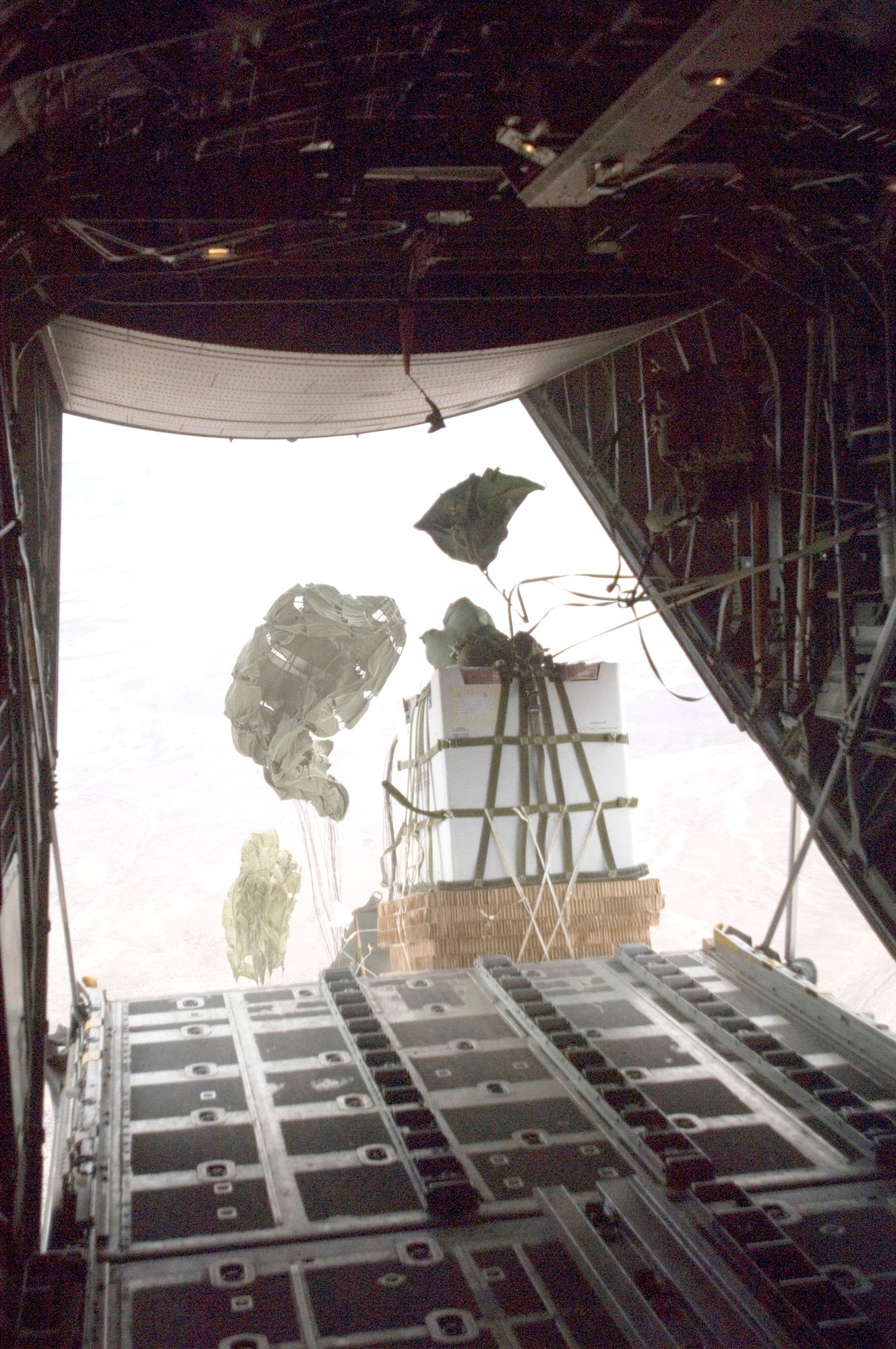 Six 1,200-pound Improved Container Delivery System bundles of water and Meals, Ready to Eat are dropped off a C-130 Hercules to support the Army's 82nd Airborne Division in Iraq Feb. 16. This mission marked the first time the Air Force employed the Joint Precision Airdrop System in combination with the I-CDS to support Operation Iraqi Freedom. The aircrew is assigned to 777th Expeditionary Airlift Squadron. (U.S. Air Force photo/Tech. Sgt. Cecilio M. Ricardo Jr.)