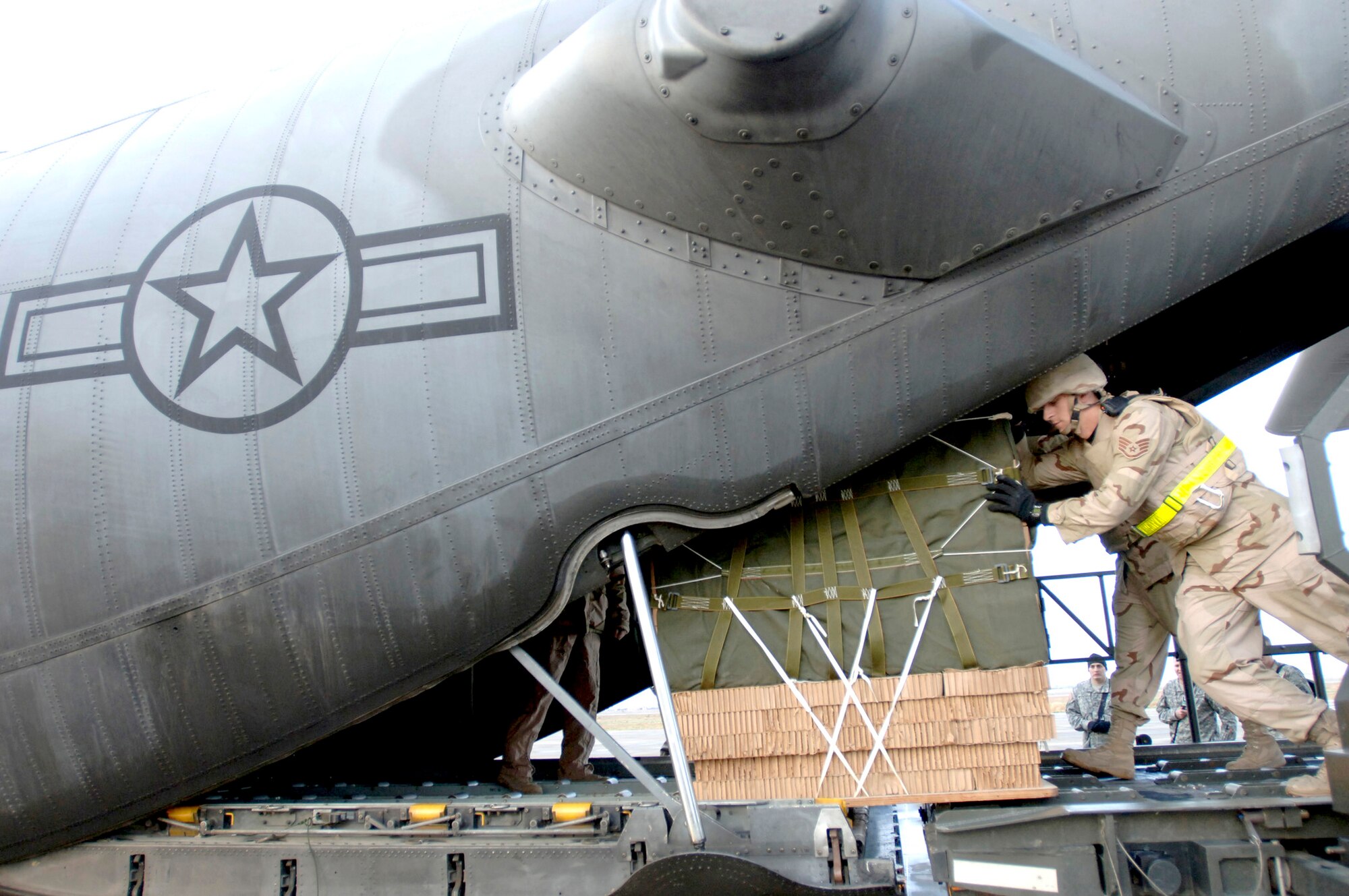 Staff Sgt. Morgan Abner loads six 1,200-pound bundles of water and Meals, Ready to Eat onto a C-130 Hercules Feb. 16 at Balad Air Base, Iraq, in preparation for the first Improved Container Delivery System airdrop mission in support of Operation Iraqi Freedom. Sergeant Abner is an aerial port member assigned to the 332nd Expeditionary Logistics Readiness Squadron. (U.S. Air Force photo/Tech. Sgt. Cecilio M. Ricardo Jr.) 