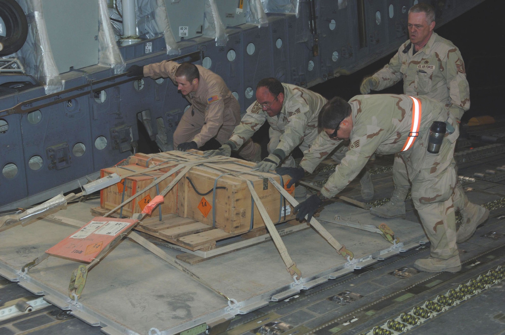 Airmen from the 455th Expeditionary Logistics Readiness Squadron maneuver cargo from a K-loader to the back of a C-17. From left, loaadmaster Senior Airman Jeseph Vondohlen, Tech. Sgt. Edward Johnston, Tech. Sgt. Brooke Biehl, and Master Sgt. John Laing. (U.S. Air Force photo/Staff Sgt. Kevin Tomko)