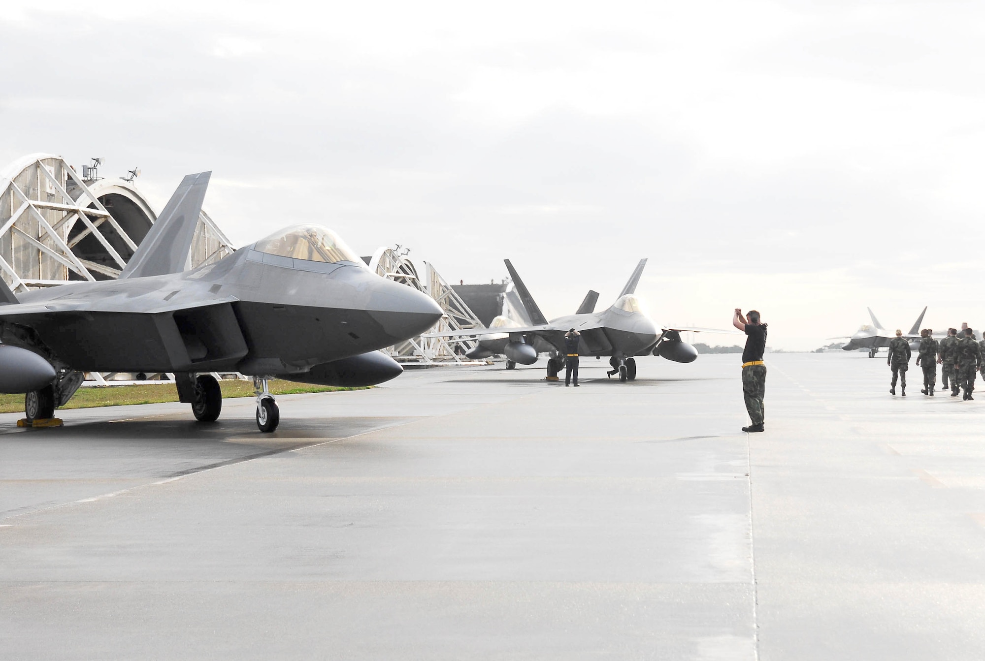 Crew chiefs park two F-22 Raptors after landing at Kadena Air Base, Japan, Feb. 18, marking the aircraft's first overseas deployment. Twelve Raptors along with more than 250 Airmen are deployed from Langley Air Force Base, Va., to Kadena as part of an air expeditionary force rotation. (U.S. Air Force photo/Airman Sheila deVera)